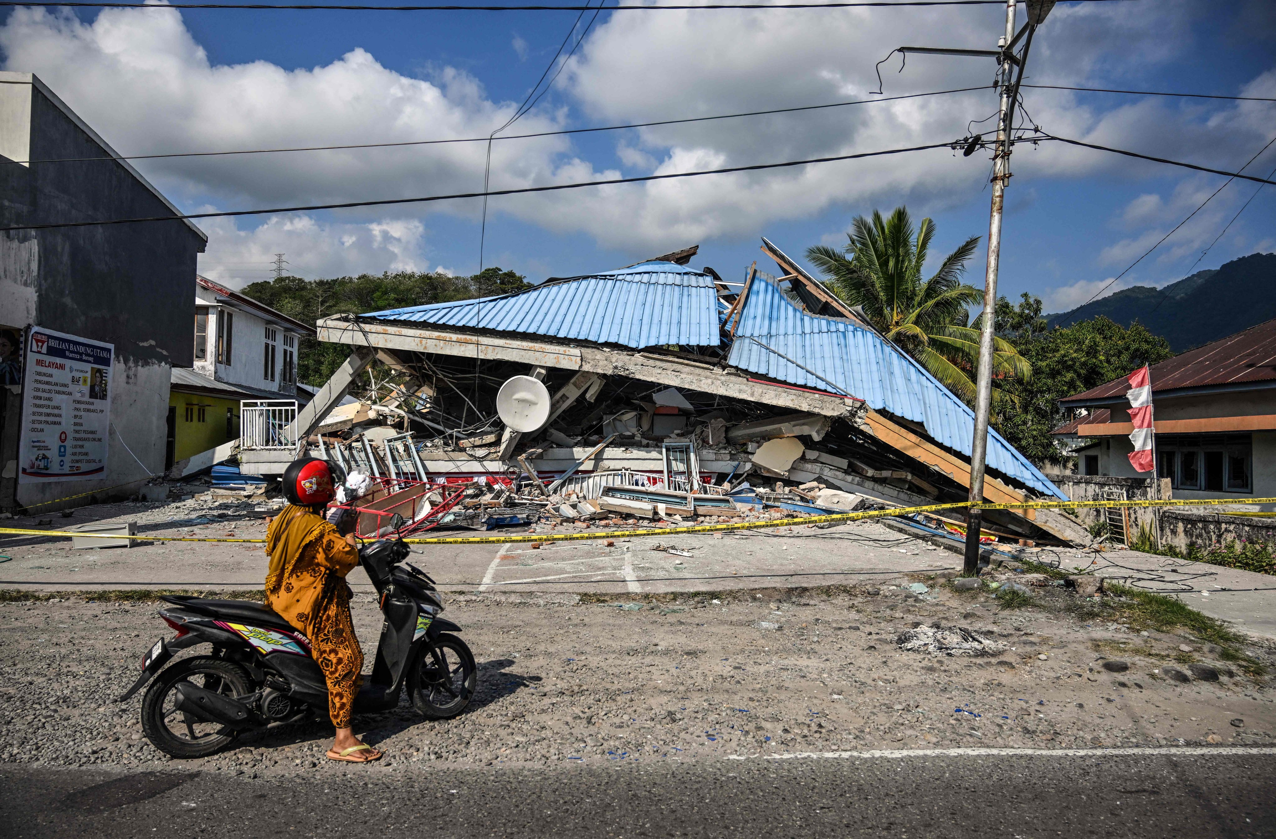A woman looks at a collapsed building following a 7.7-magnitude earthquake in Borong, East Nusa Tenggara on Sunday. Photo: AFP