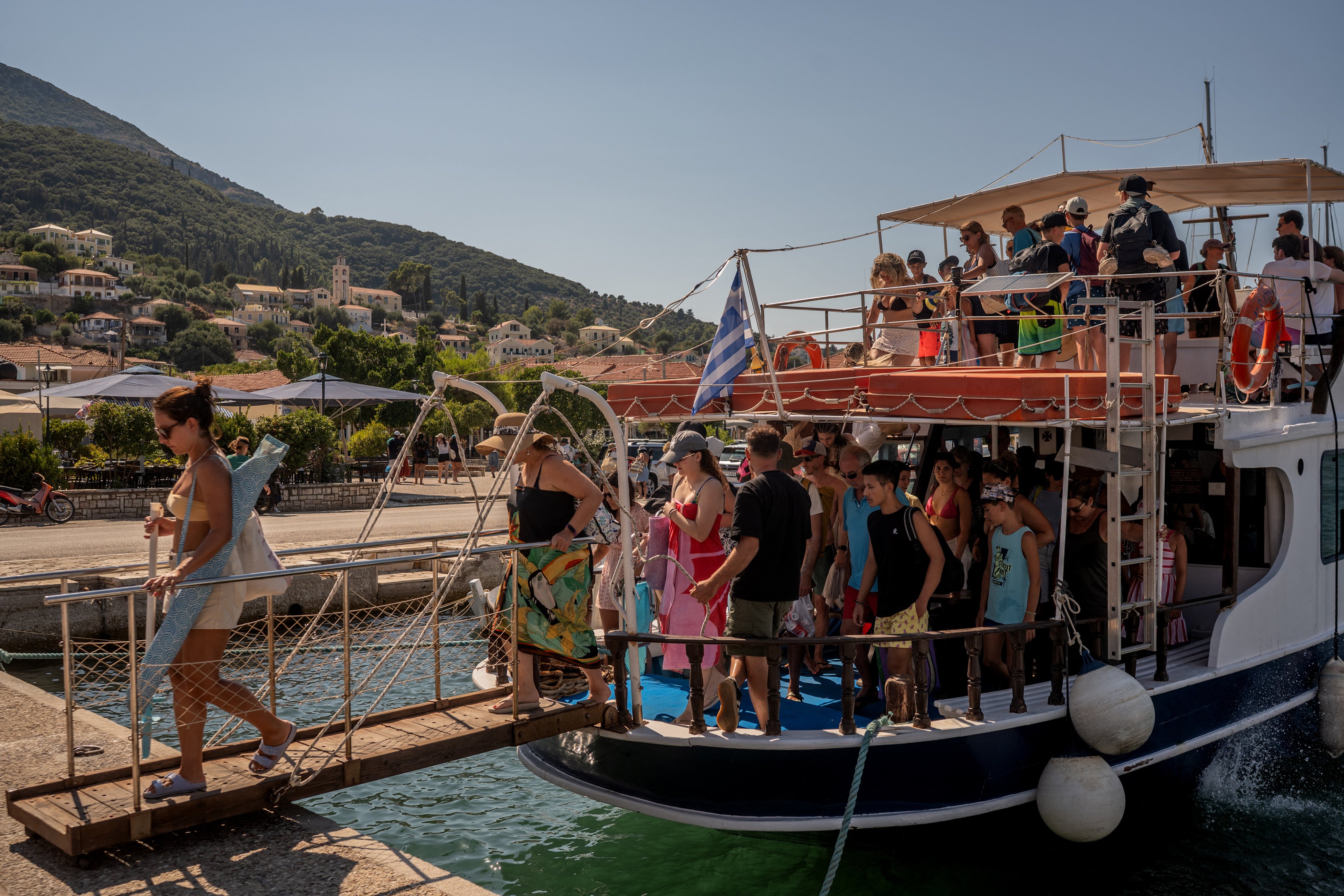 Tourists disembark from a boat after returning from nearby beaches on the island of Ithaca on August 3, 2026. Ithaca is widely believed to be the home of the hero Odysseus in Homer’s Odyssey. Photo: AFP