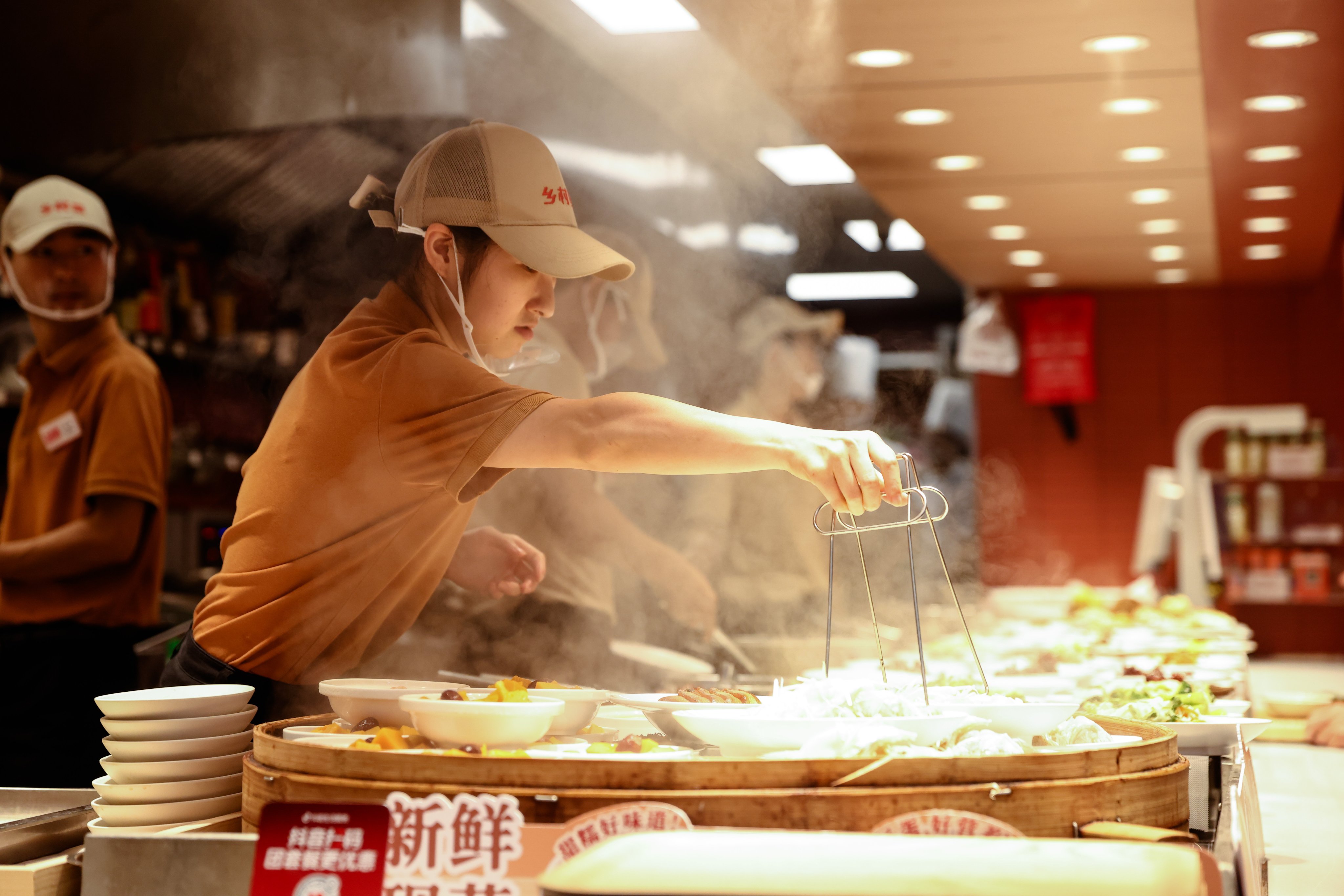 Employees work in a restaurant in Beijing. Photo: EPA