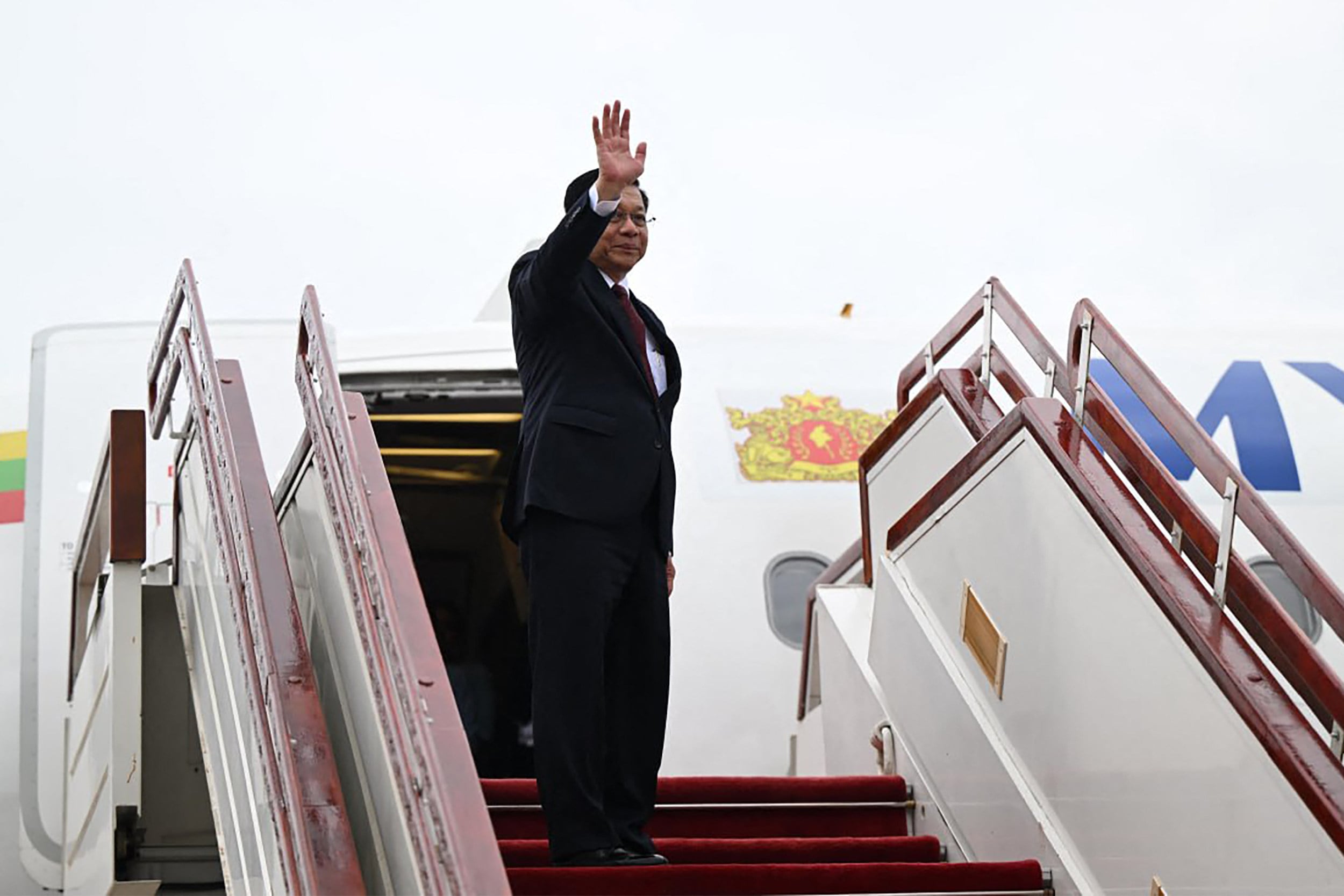 Myanmar’s President Min Aung Hlaing waves as he boards a plane bound for Russia on Monday. Photo: Myanmar’s Presidential Press and Information Bureau / AFP