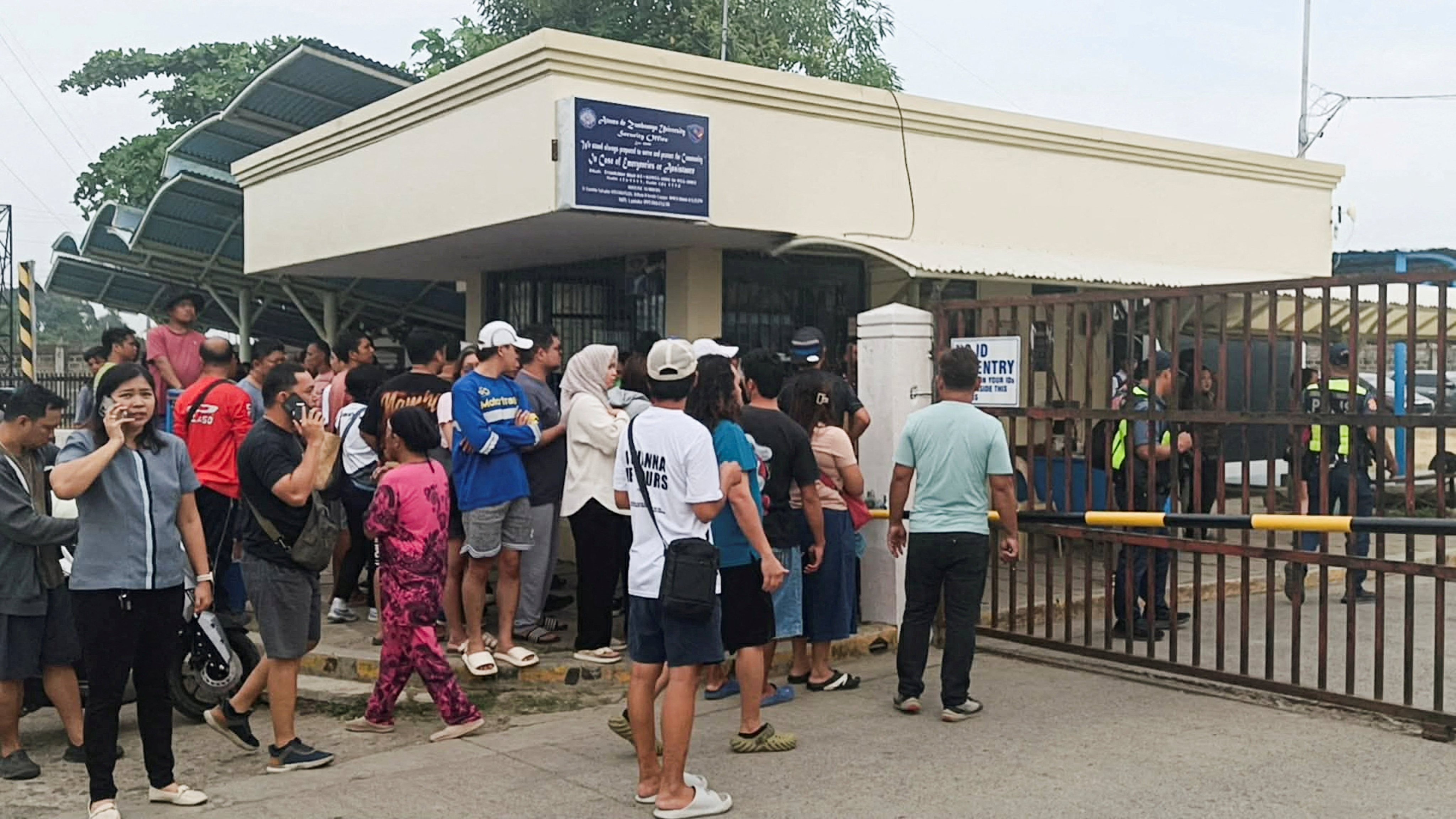 People wait for news outside Ateneo de Zamboanga University after a shooting that killed two people on Tuesday. Photo: Reuters