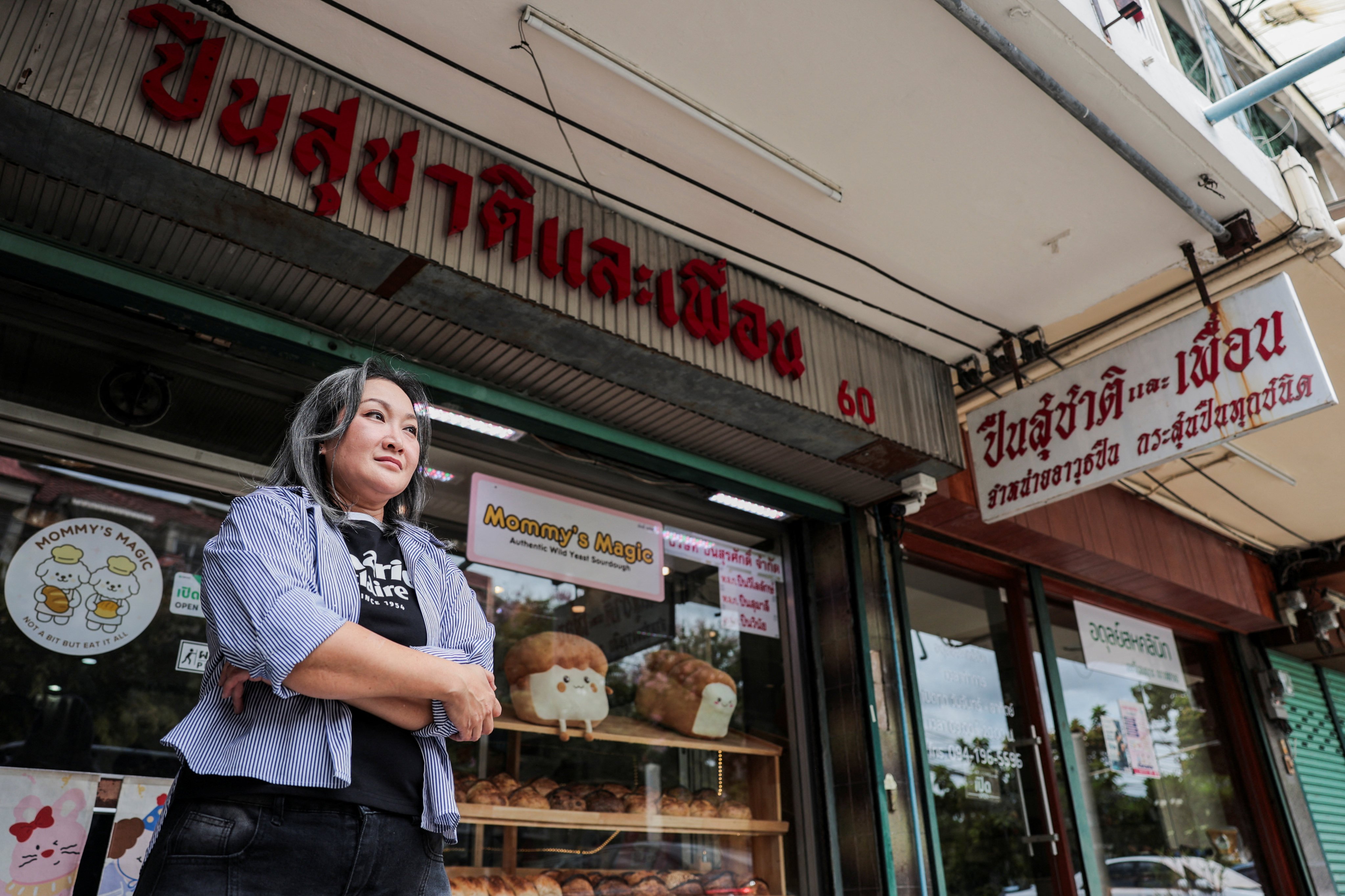 Warintorn Boonyachai, stands outside Suchart and Friends Gun Shop, which has switched to selling sourdough bread, on Friday. Photo: Reuters