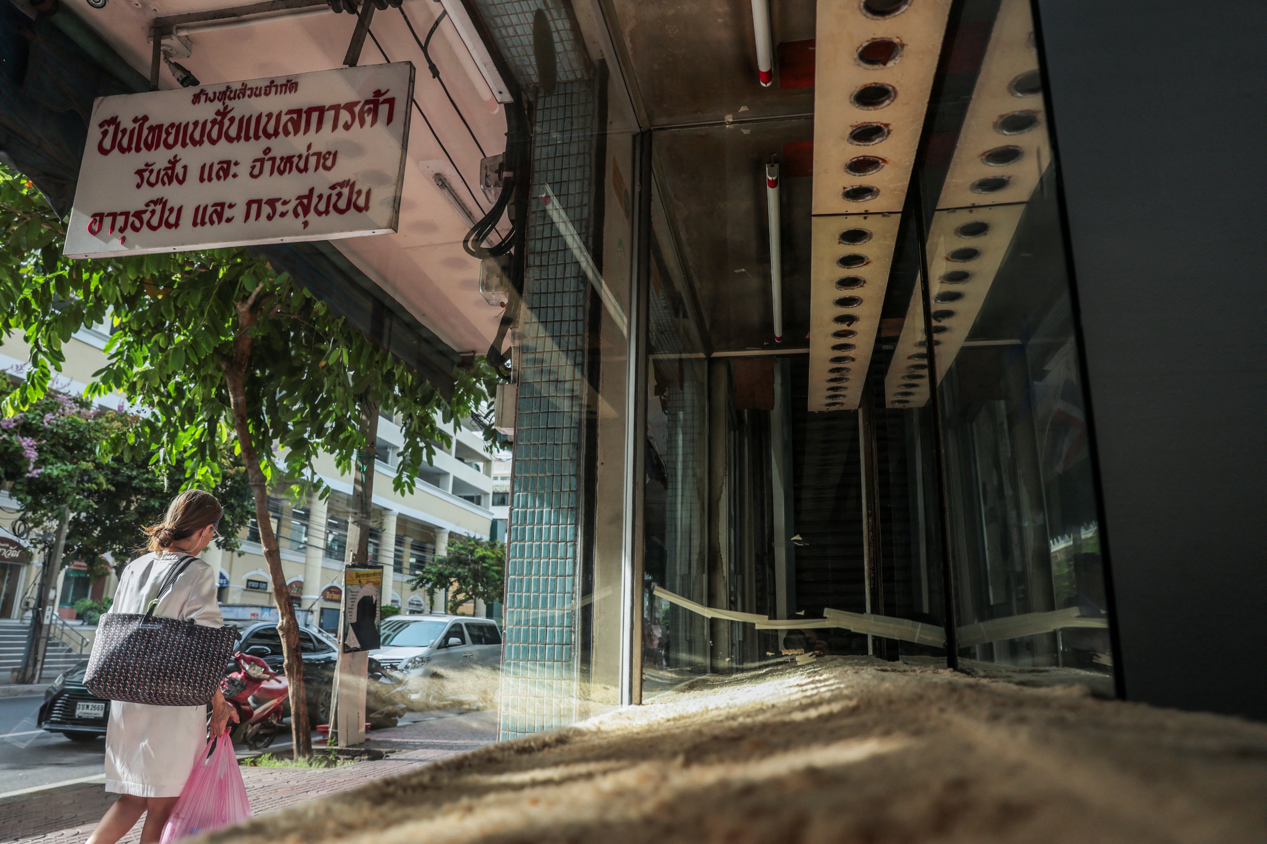 A woman walks past a gun shop with empty display shelves in Bangkok’s historic gun district on Friday. Photo: Reuters
