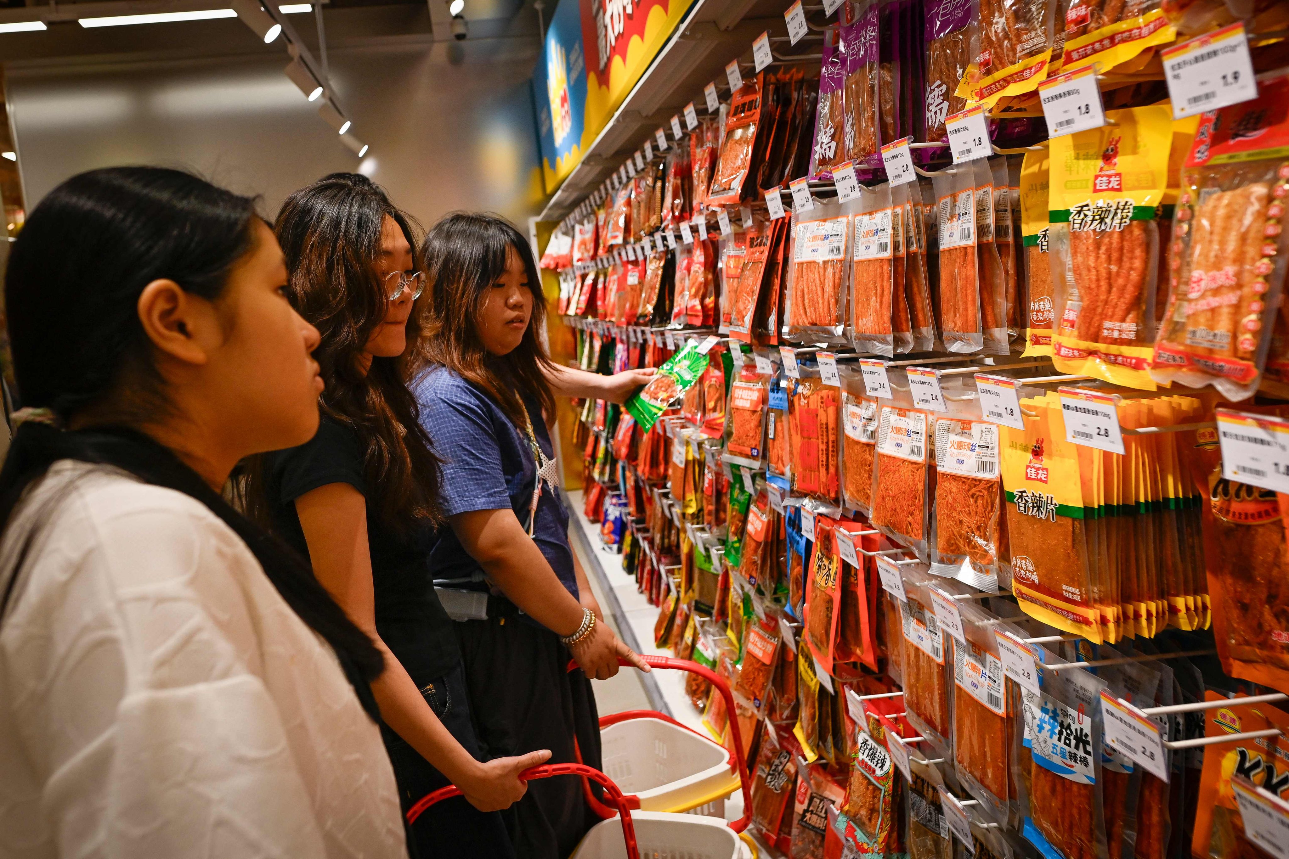 People look at a wall of spicy strips at a market in Changsha, in Hunan province. Spicy latiao, originally developed as emergency supplies, are now a global sensation. Photo: AFP