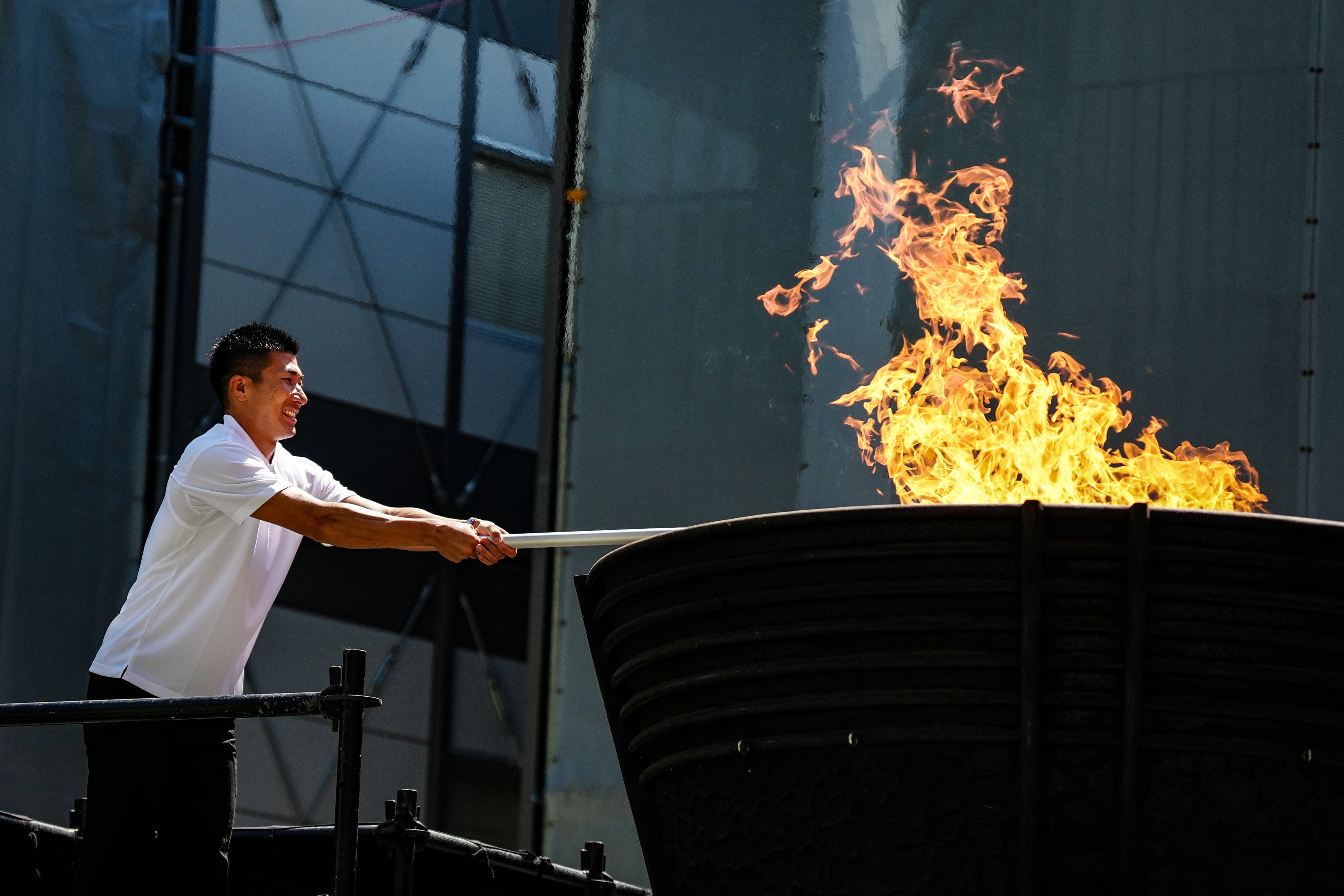 Japanese sprinter Kiryu Yoshihide lights the torch from the cauldron during the flame-lighting ceremony for the 20th Asian Games in Tokyo on Tuesday. Photo: Xinhua