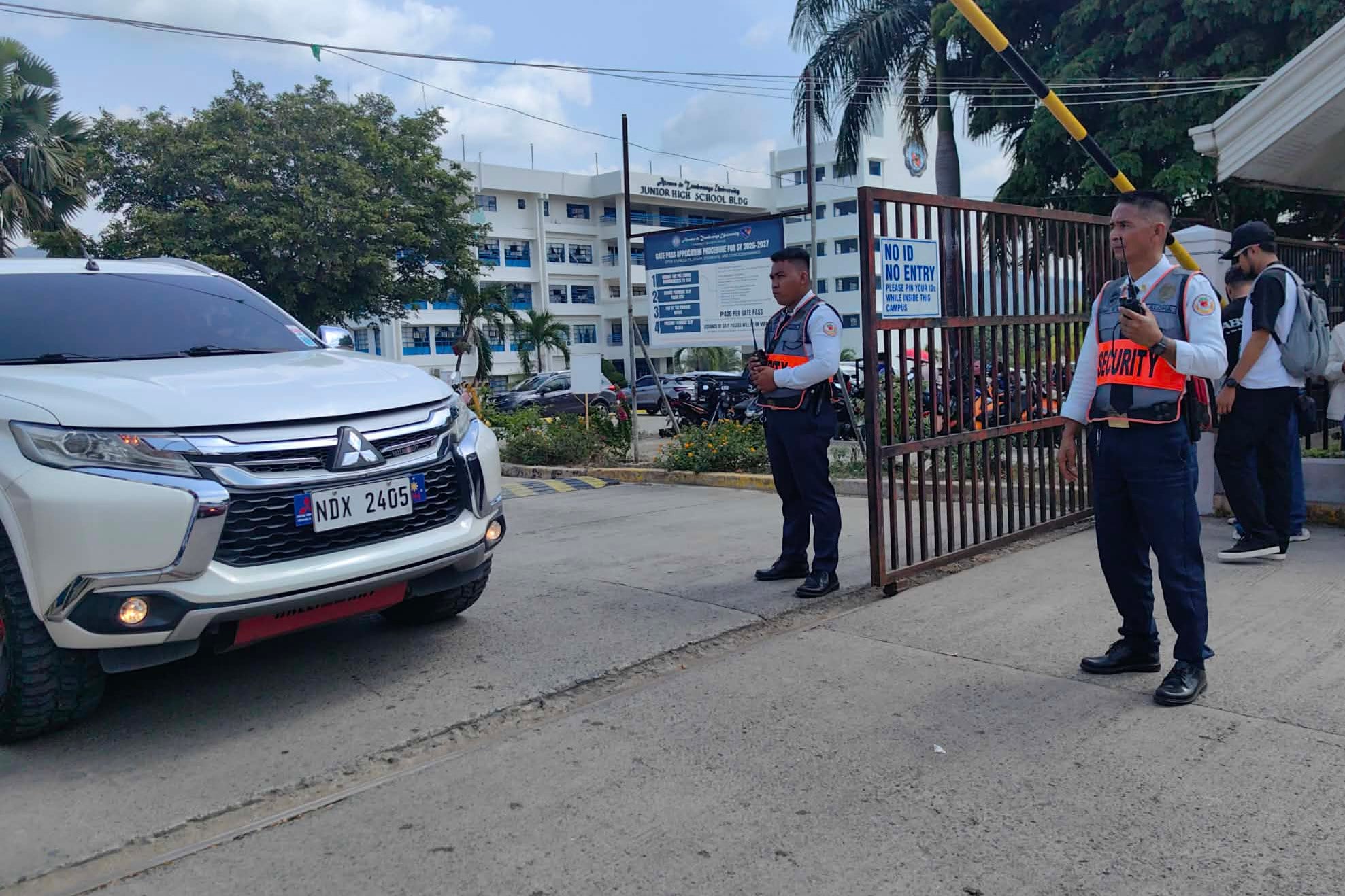 Security guards keep watch as vehicles exit the Ateneo de Zamboanga University following a shooting on Tuesday. Photo: AP