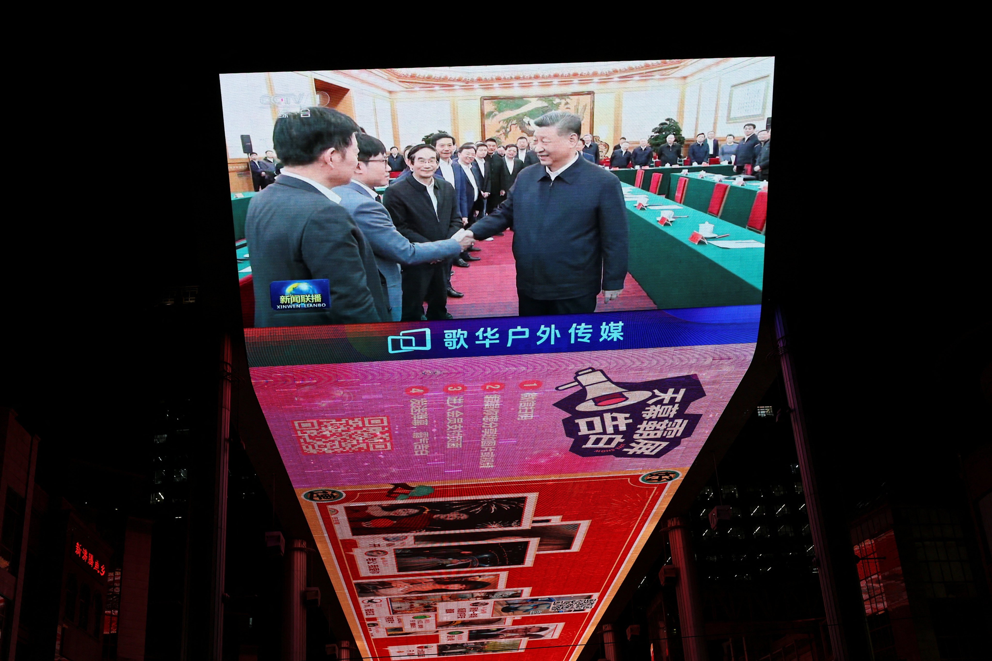 A giant screen shows news footage of Chinese President Xi Jinping shaking hands with DeepSeek founder Liang Wenfeng during a symposium on private enterprise, at a shopping complex in Beijing on February 17, 2025. China’s treatment of its billionaire class differs from the United States’. Photo: Reuters