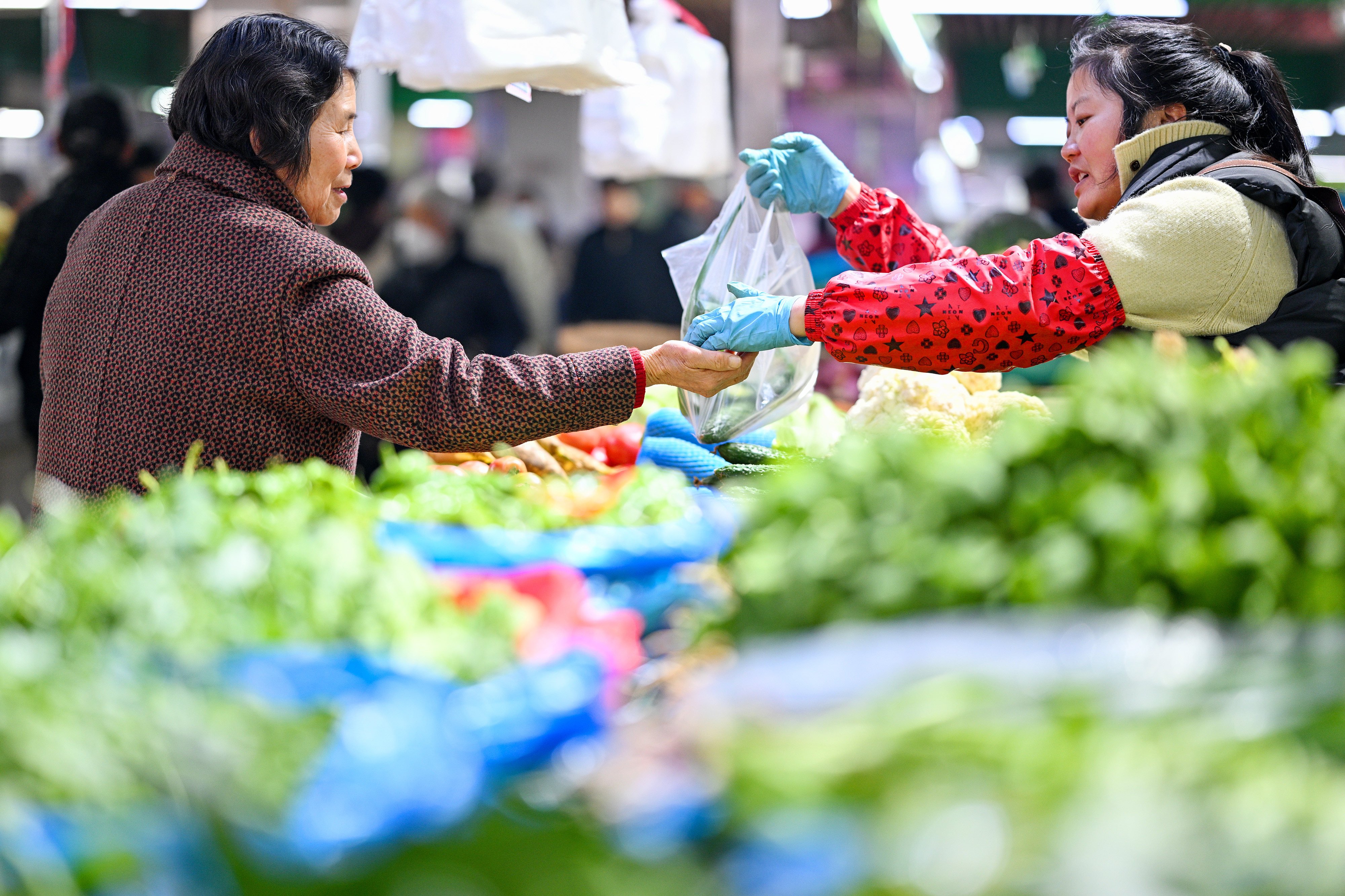 A customer buys vegetables at a market in Nanjing, in eastern China’s Jiangsu province, on March 9. Photo: Xinhua