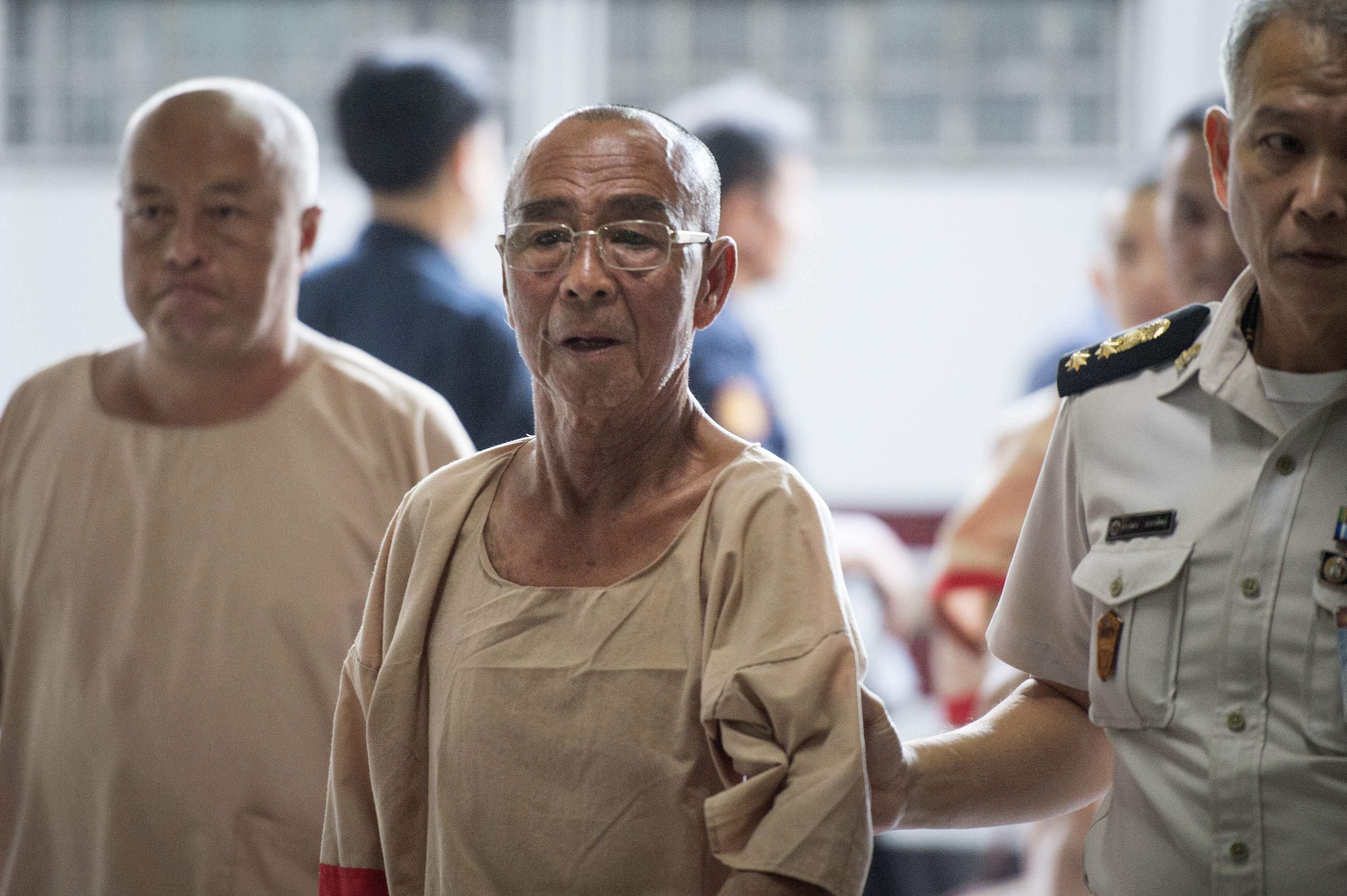 Laota Seanlee (centre) is escorted into a criminal court in Bangkok on December 13, 2017. Photo: AFP
