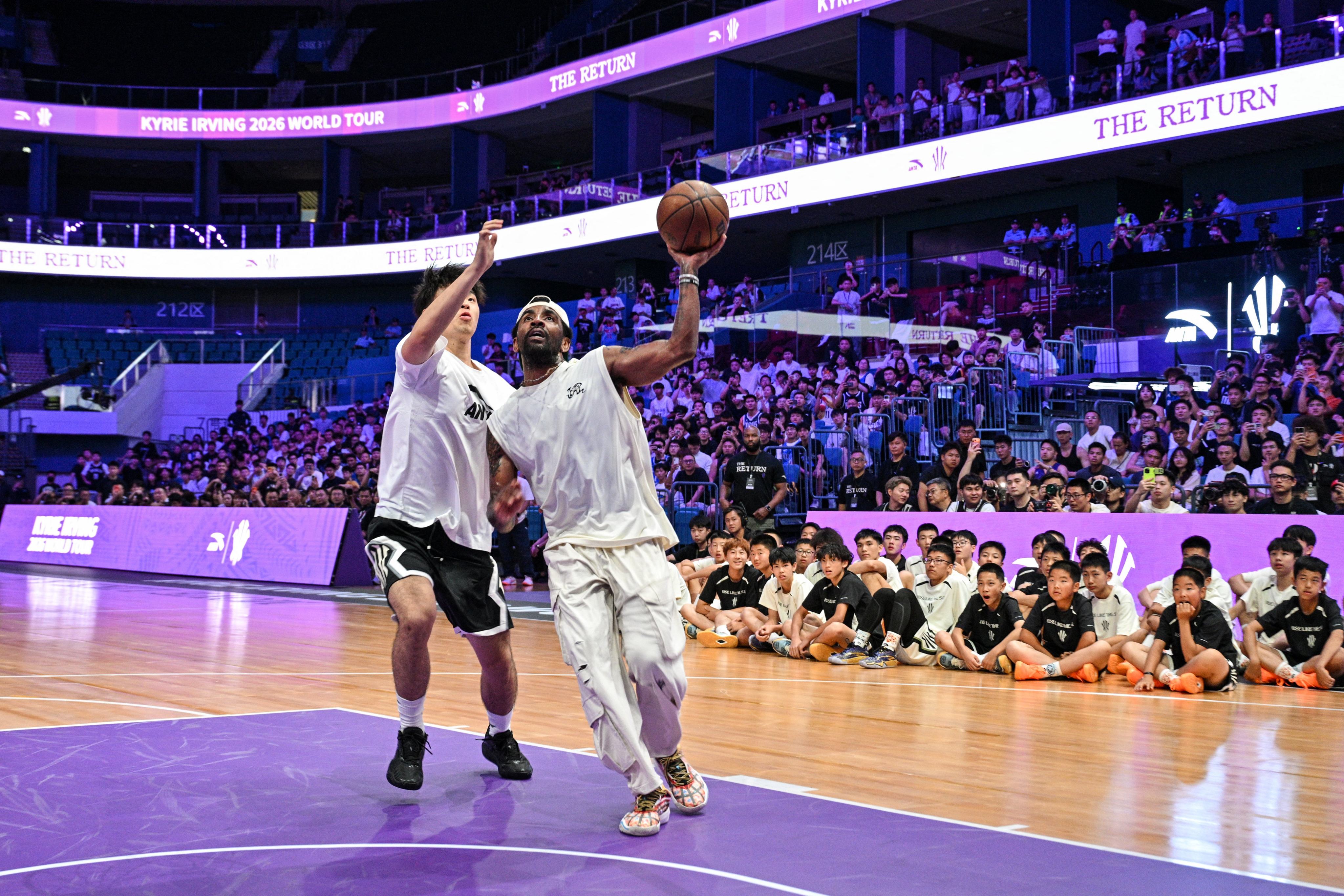 NBA star Kyrie Irving (right), the chief creative officer of Chinese sportswear brand Anta, at an event with fans in Chengdu in June. Photo: Hector Retamal/AFP
