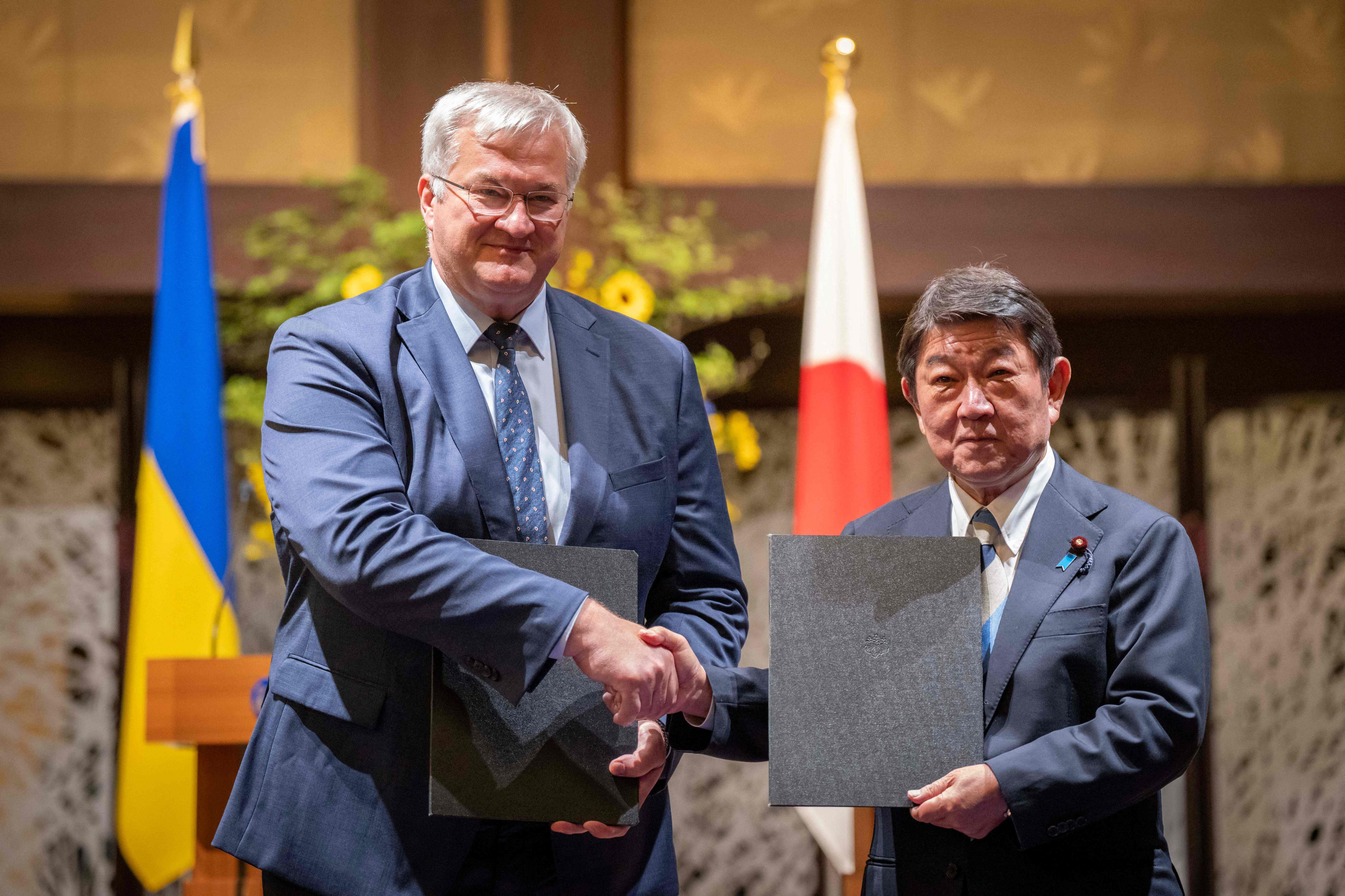 Japan’s Foreign Minister Toshimitsu Motegi (right) and his Ukrainian counterpart Andriy Sybiga pose after a signing ceremony in Tokyo on July 1. Photo: AFP