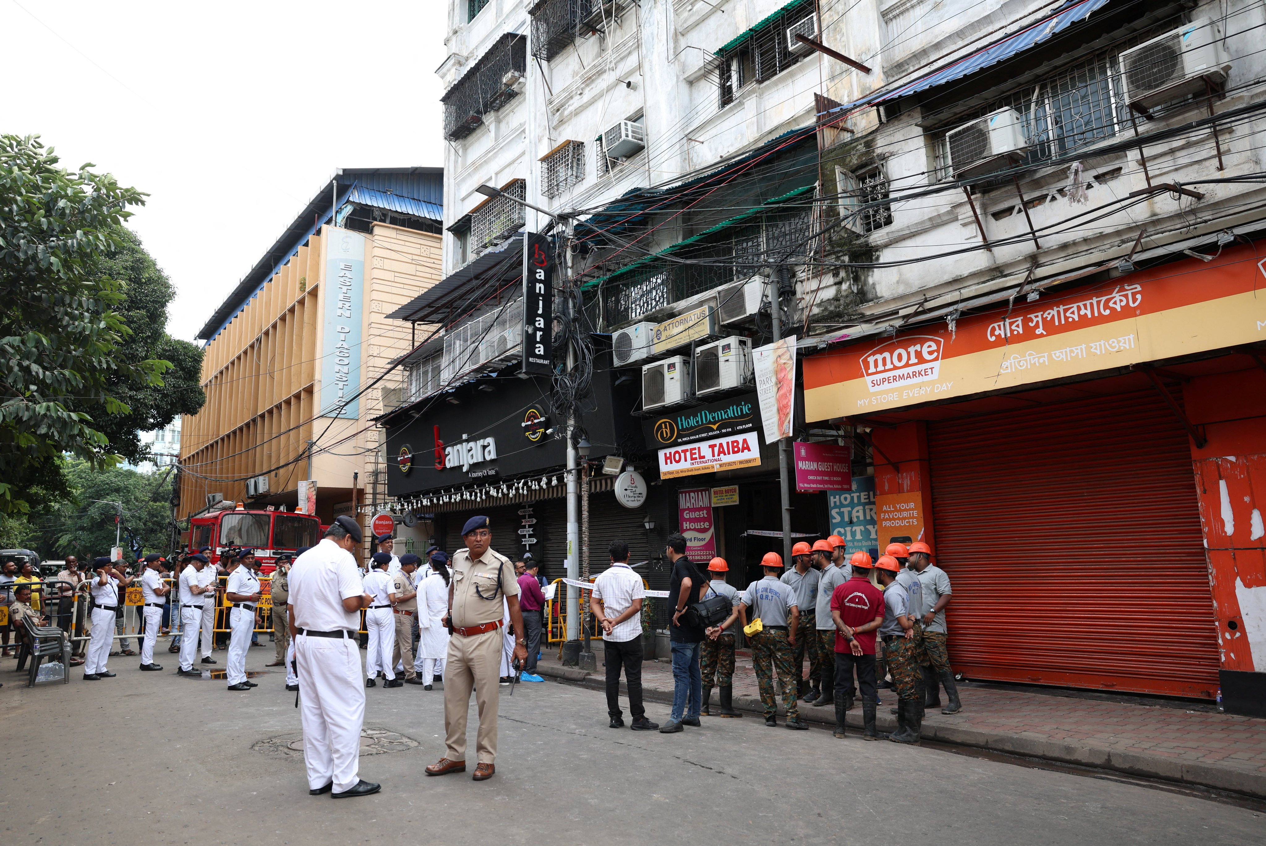 Firefighters and other officials stand on the street in the aftermath of hotel a fire that killed several people in Kolkata on Wednesday. Photo: Reuters