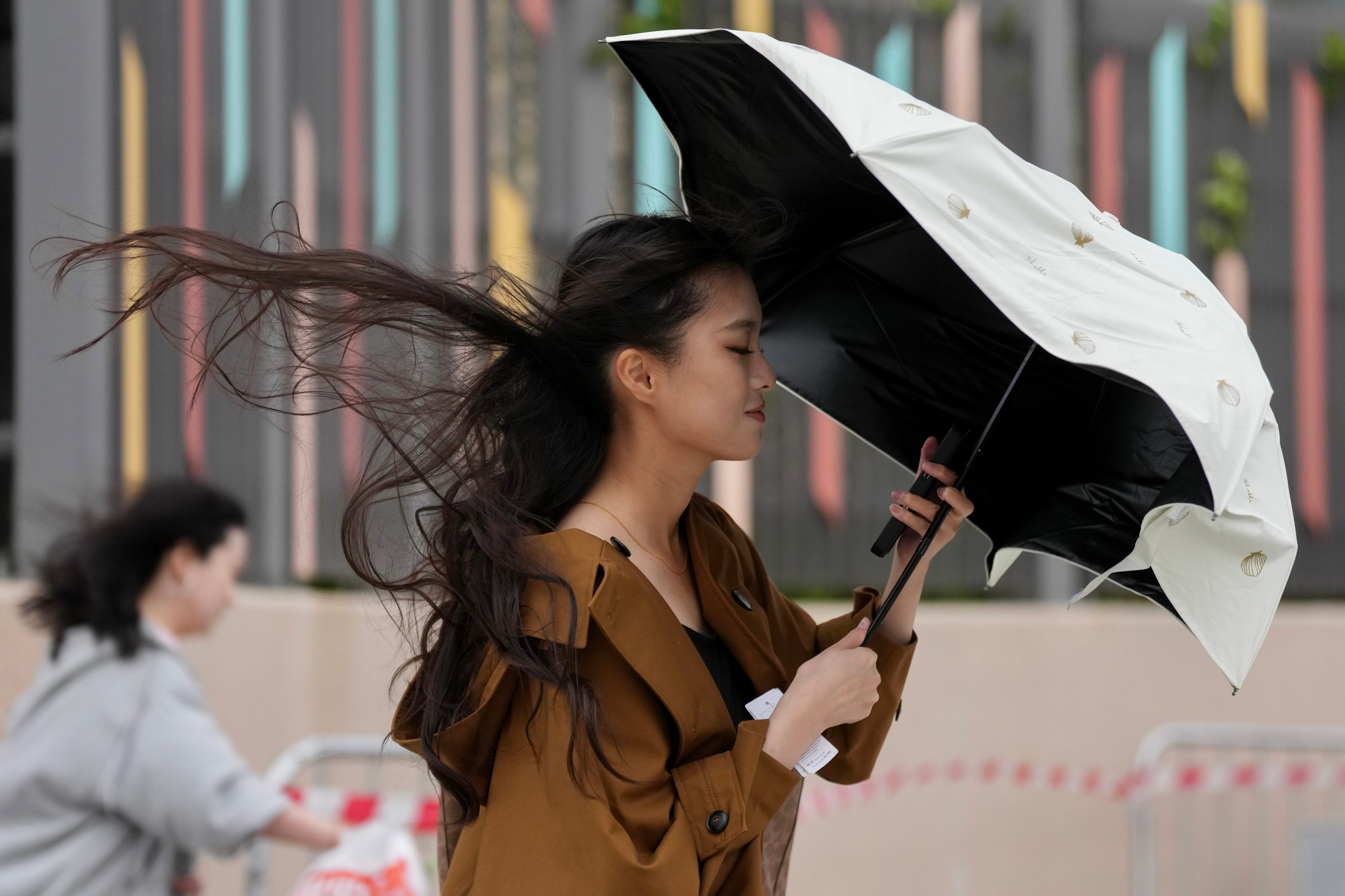 A woman braves strong winds earlier this year. Hong Kong could be set for stormy weather over the weekend. Photo: Karma Lo