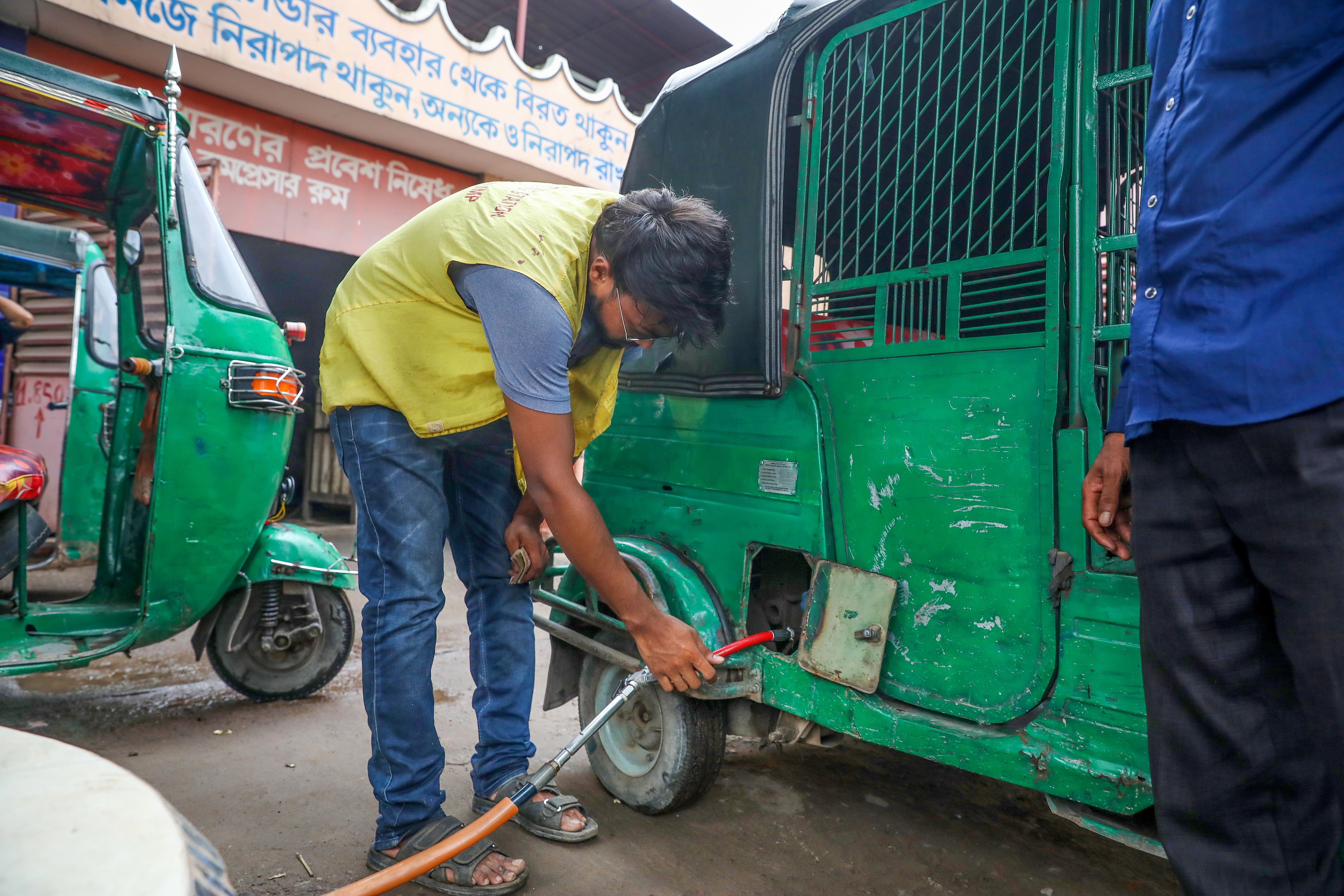 A station worker refuels an auto-rickshaw that runs on compressed natural gas at a filling station in Dhaka on Monday amid an energy crisis in Bangladesh. Photo: EPA