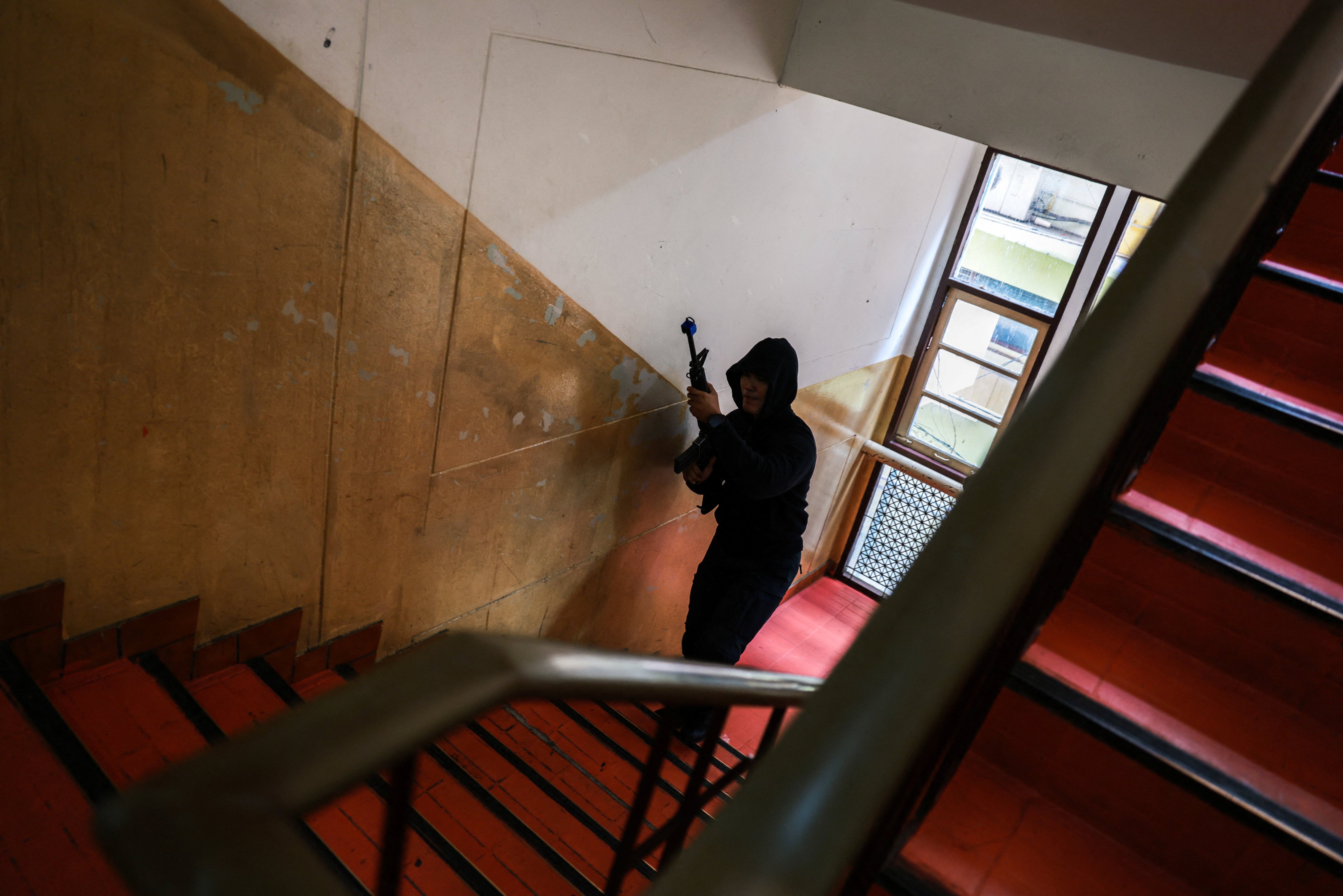 A police officer acting as an active shooter holding a rifle walks during a drill to prepare for an active shooter scenario at Surasamontree School in Bangkok, Thailand, on Wednesday. Photo: Reuters