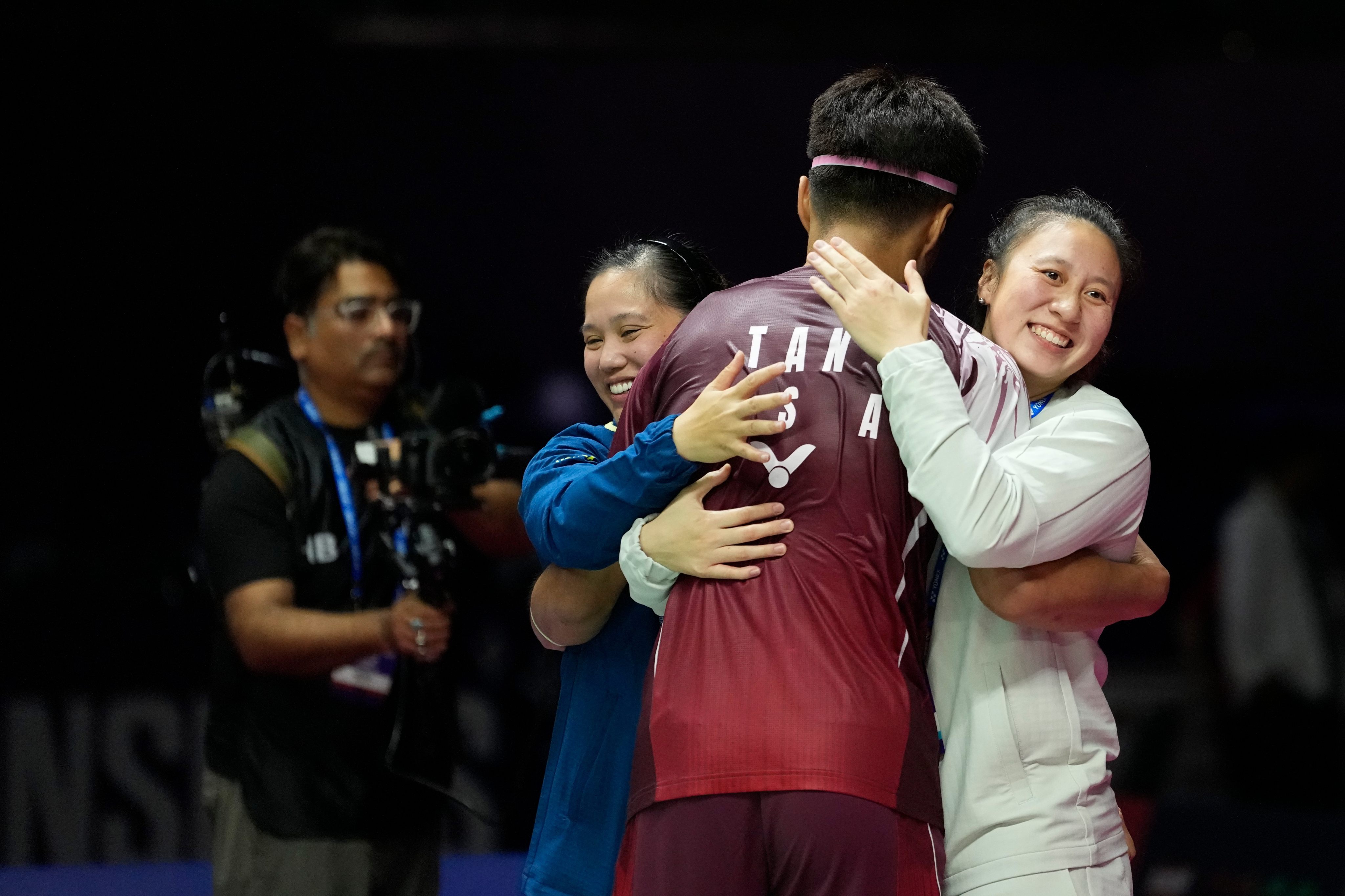 Garret Tan is hugged by US manager Paula Lynn (left) and teammate Lauren Lam after his world championships win over India’s Lakshya Sen on Wednesday. Photo: AP