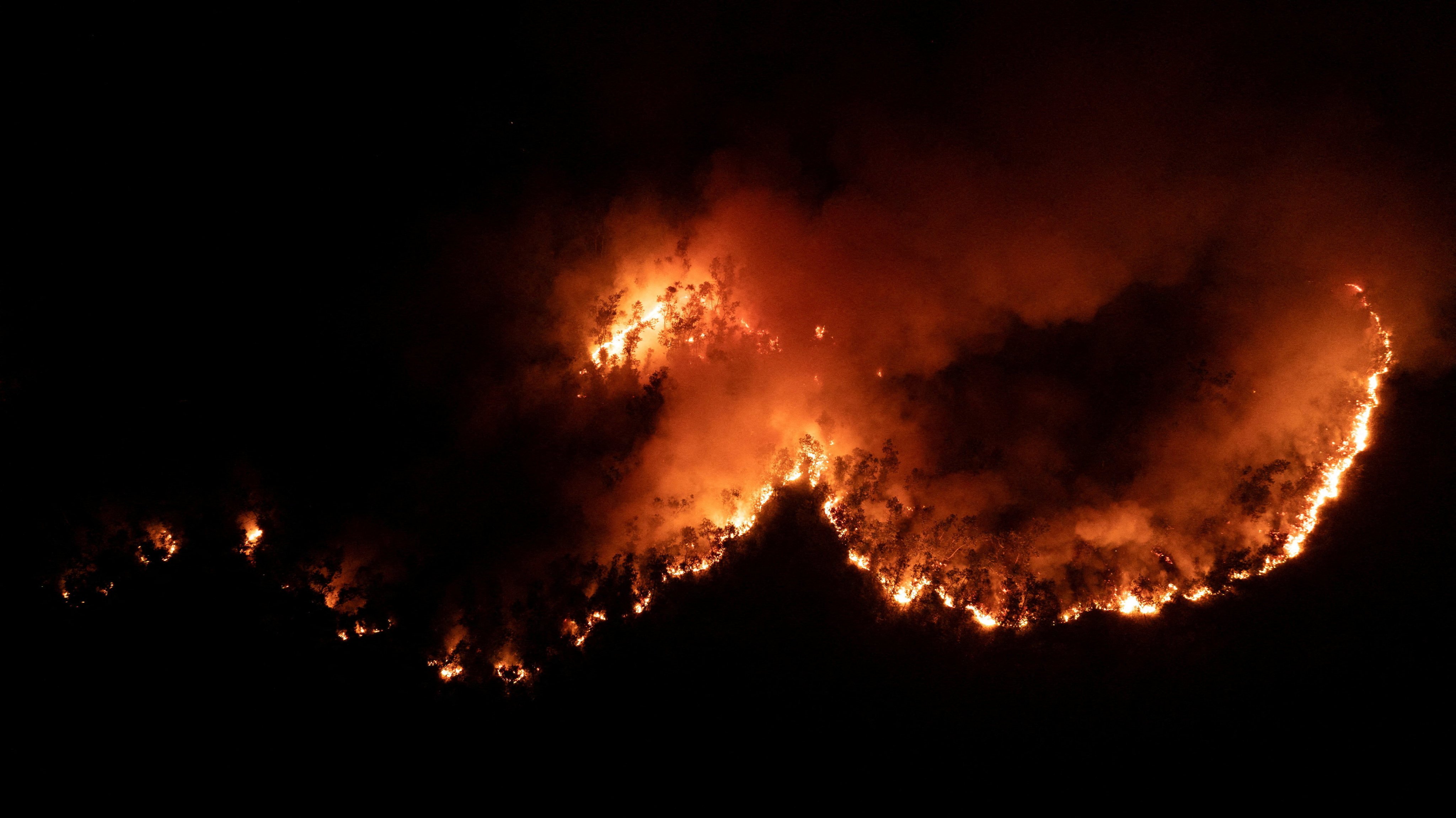 A drone view shows smoke and flames rising from wildfire burning in Palangka Raya, Central Kalimantan province, Indonesia, August 13, 2026. REUTERS/Ajeng Dinar Ulfiana