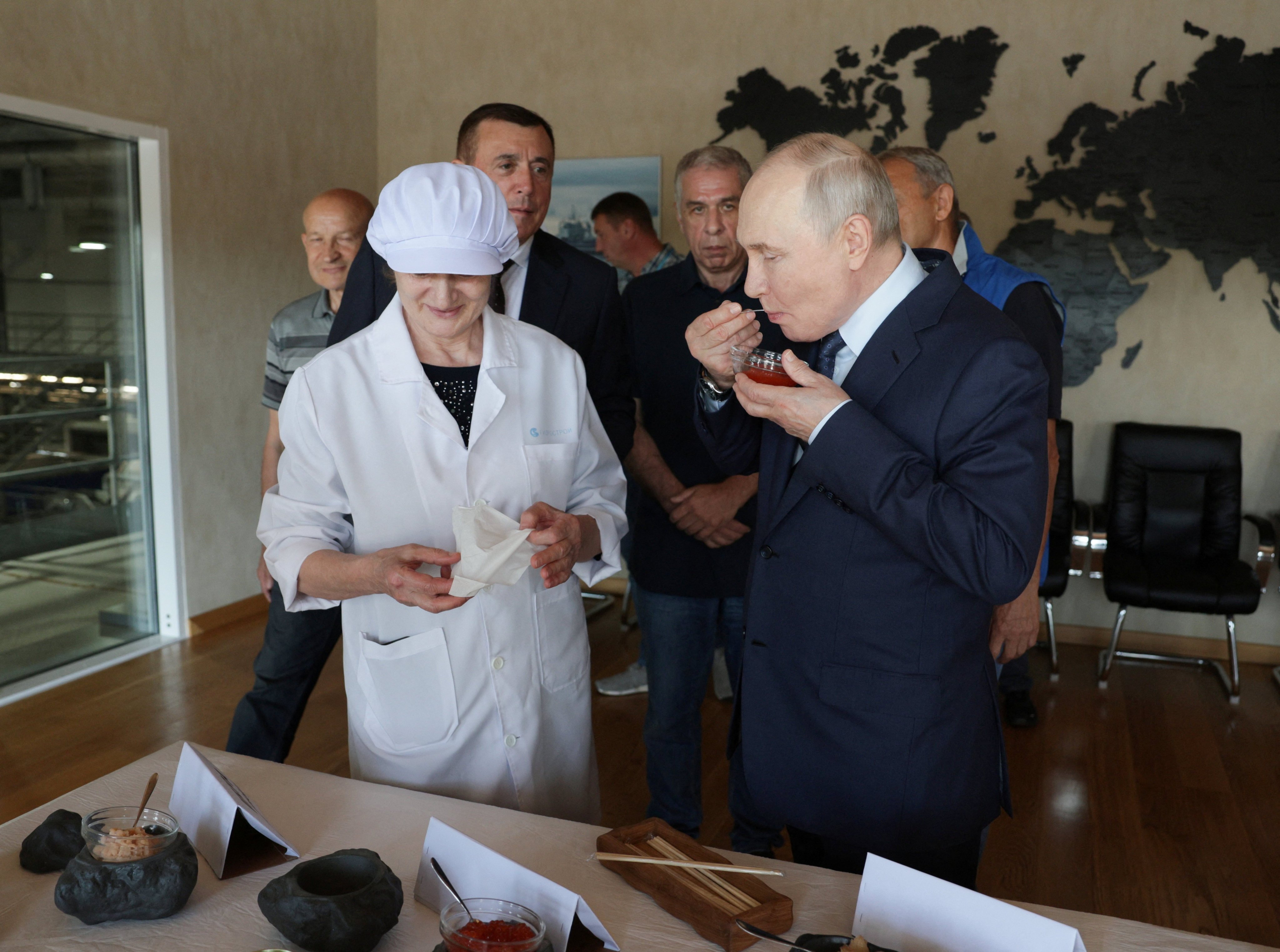 Russian President Vladimir Putin tries caviar during his visit to a fish processing complex on the Southern Kuril Island of Iturup on August 13. Photo: Sputnik via Reuters