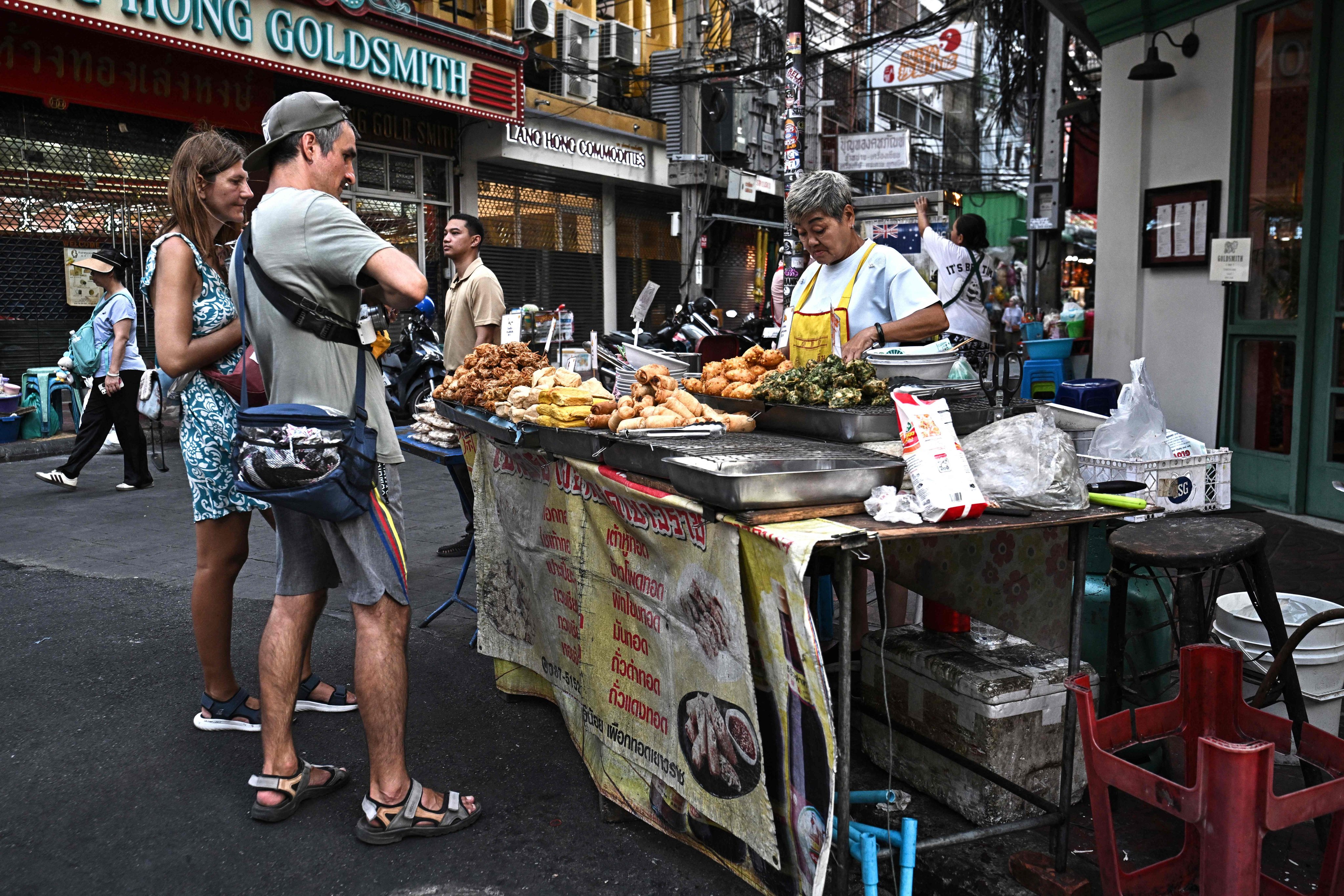 A street food vendor sells fried vegetarian snacks to visitors in Bangkok’s Chinatown on April 29. Photo: AFP