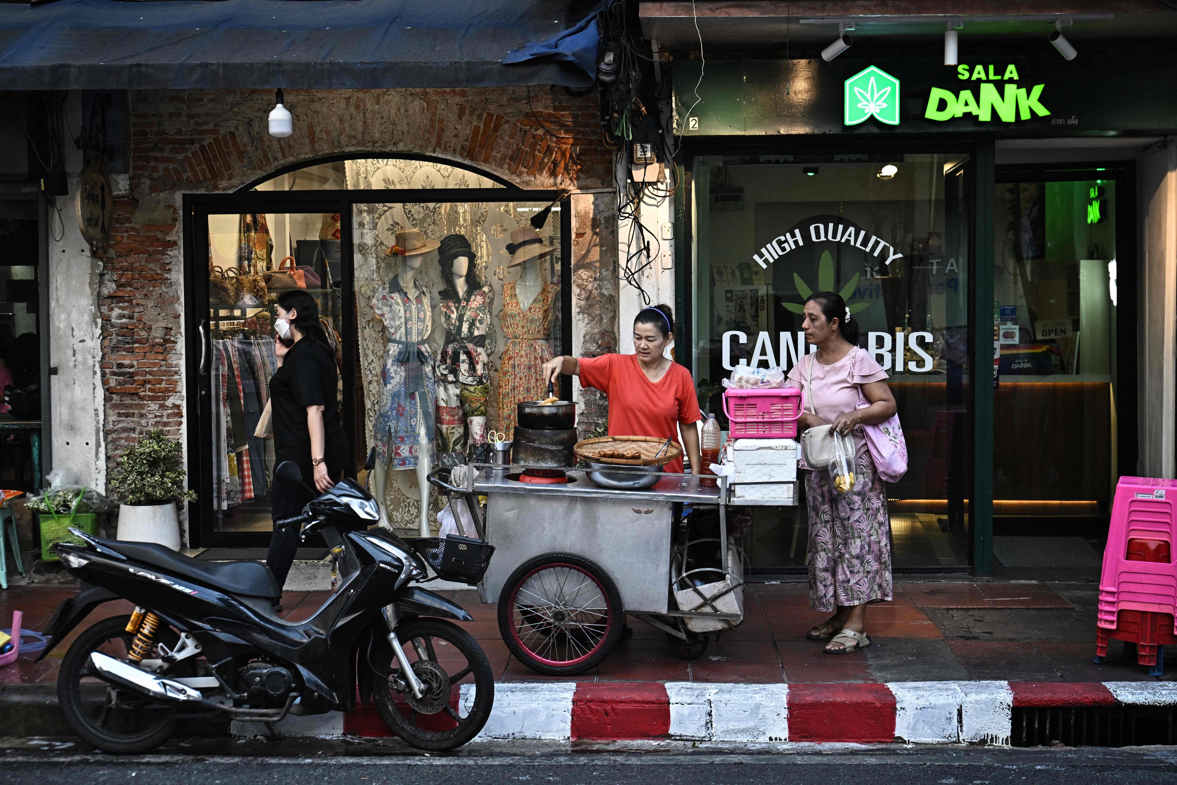 A street vendor prepares food for a customer along Silom road in Bangkok on April 30. Photo: AFP