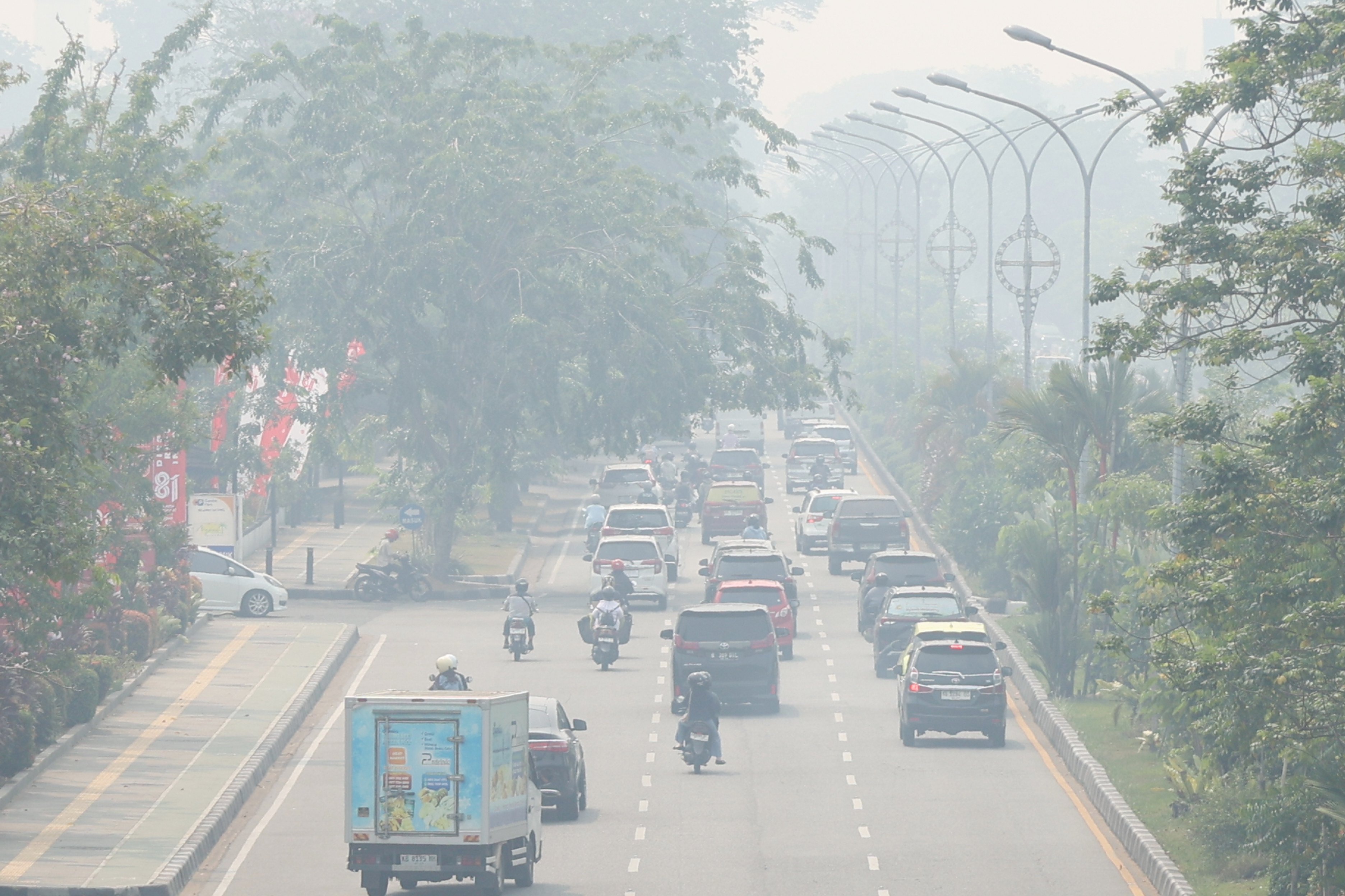 Motorists ride on a road as haze from wildfires blankets the city of Pontianak, West Kalimantan, Indonesia, on Friday. Photo: AP
