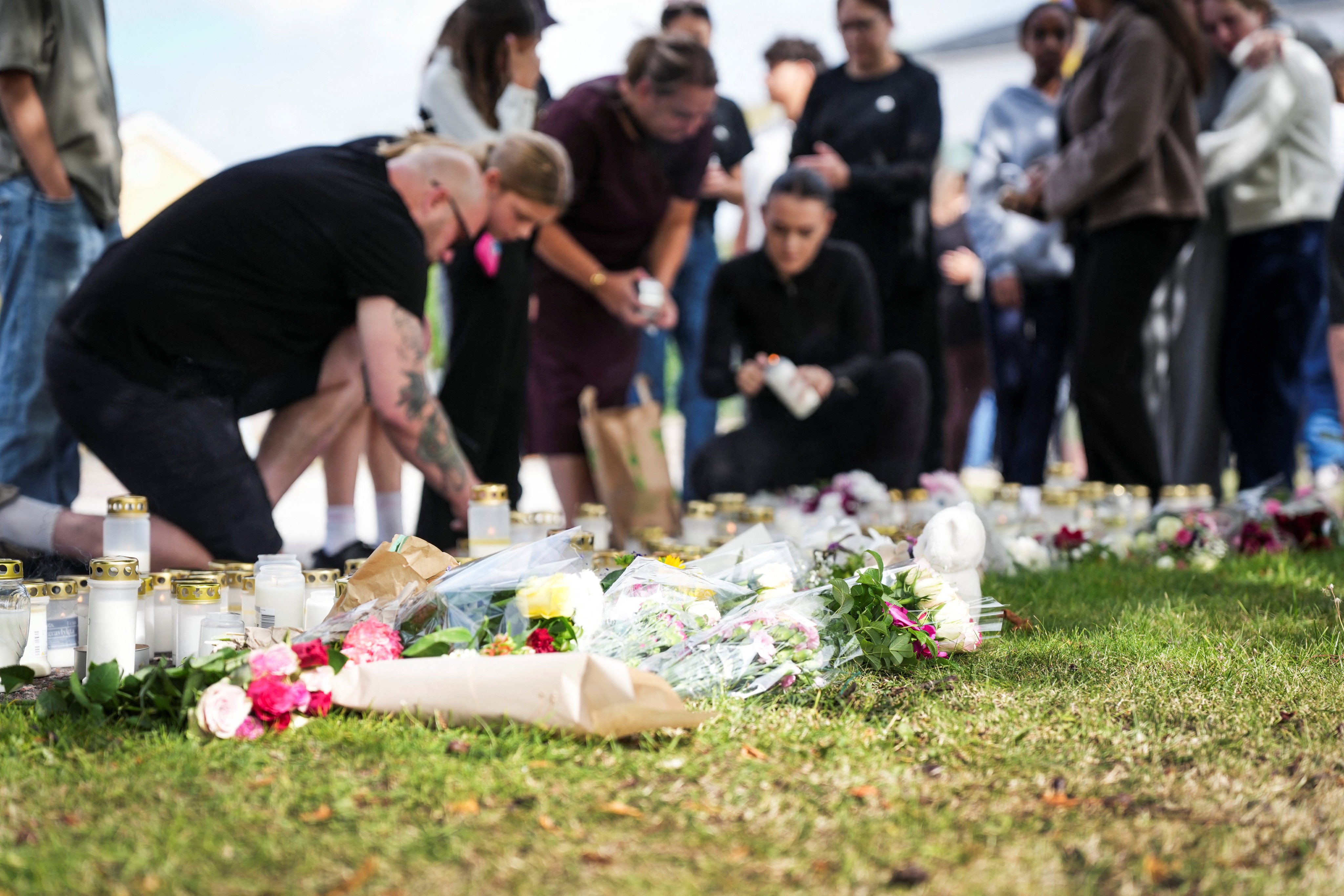 Residents leave flowers and candles at a makeshift memorial outside a shool in Fagersta, Sweden, on Saturday. Photo: Reuters