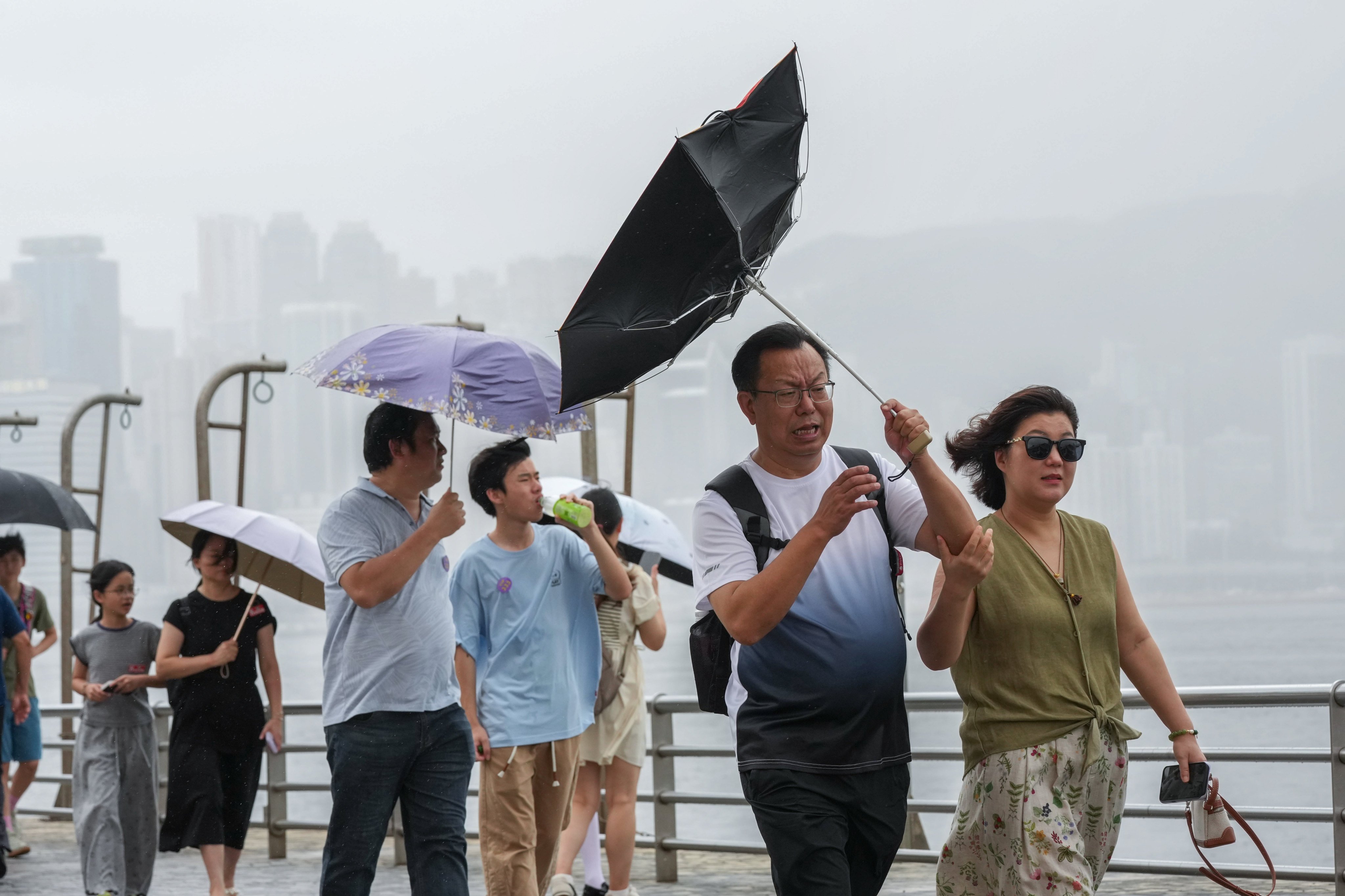 Tourists visit the Tsim Sha Tsui waterfront during stormy weather in July. The Observatory is assessing the need to issue a typhoon signal early next week. Photo: Jelly Tse
