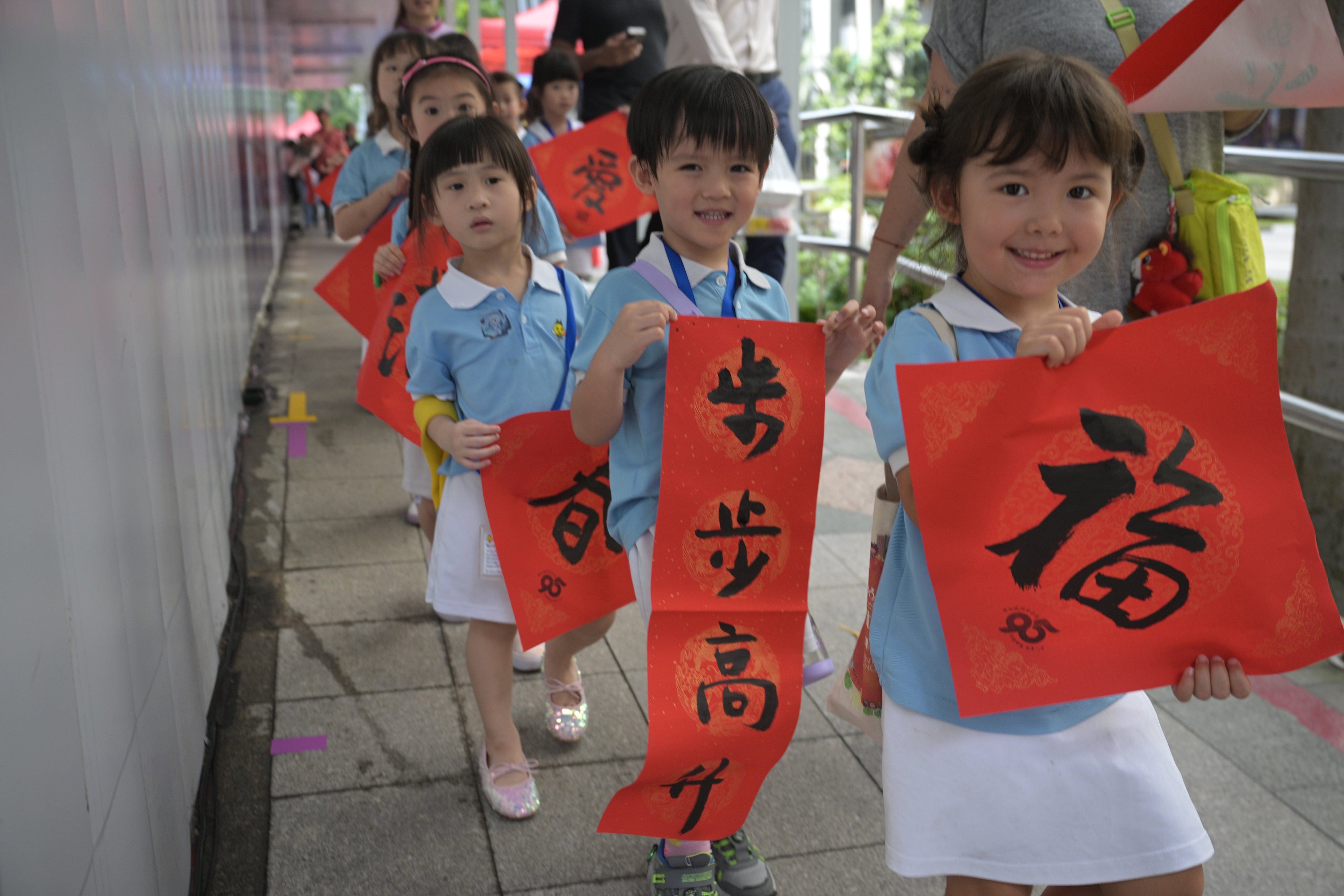 Children in Singapore show calligraphy works they have received as part of the 2026 Lunar New Year celebrations. Photo: Xinhua