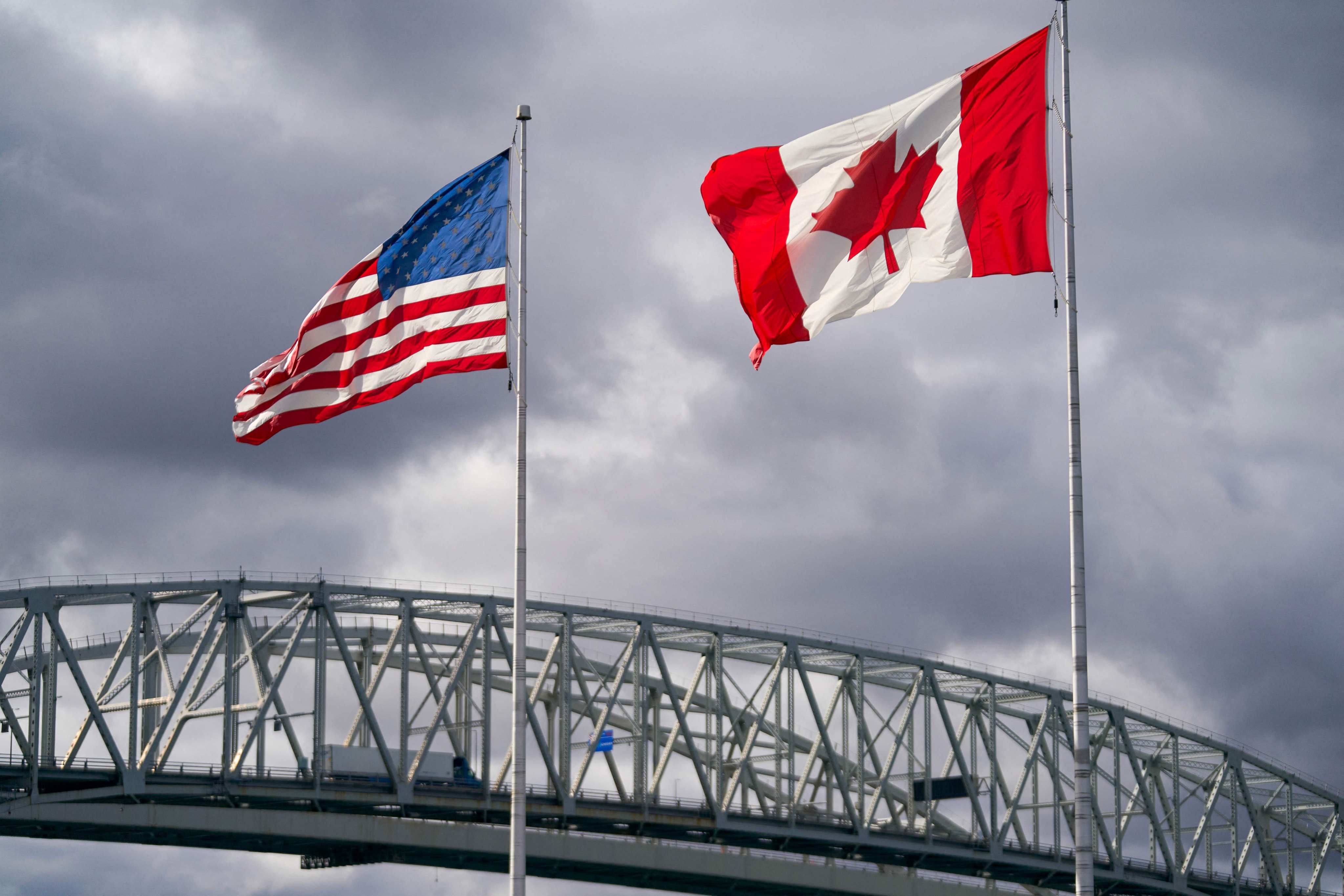 The US and Canadian flags flutter next to the Blue Water Bridge border crossing in Point Edward, Ontario. Photo: AFP