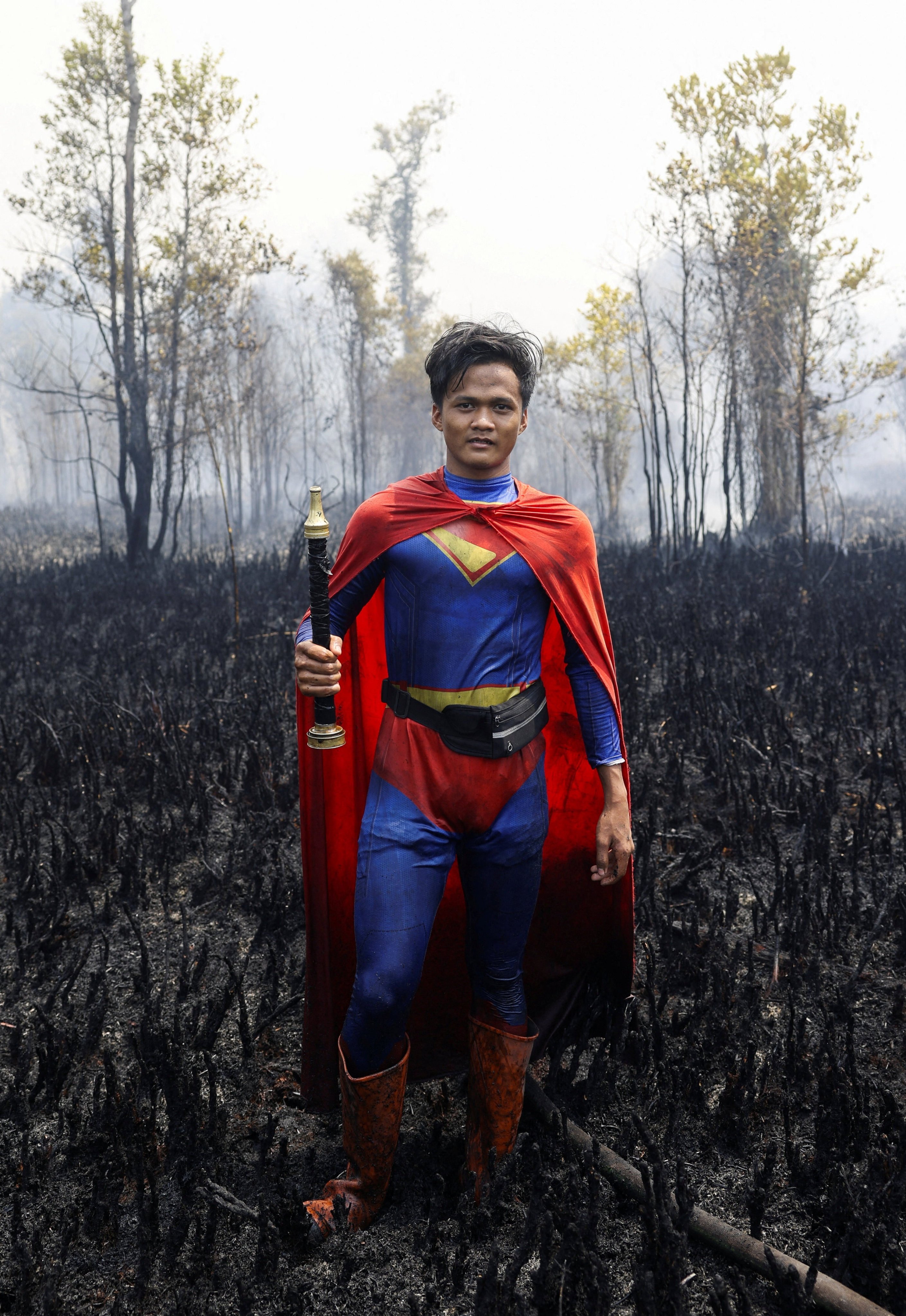 Rudiyansah, wearing a Superman costume, poses for a photograph after extinguishing a fire at a wildfire-affected area in Palangka Raya, Central Kalimantan, Indonesia, on August 14. Photo: Reuters