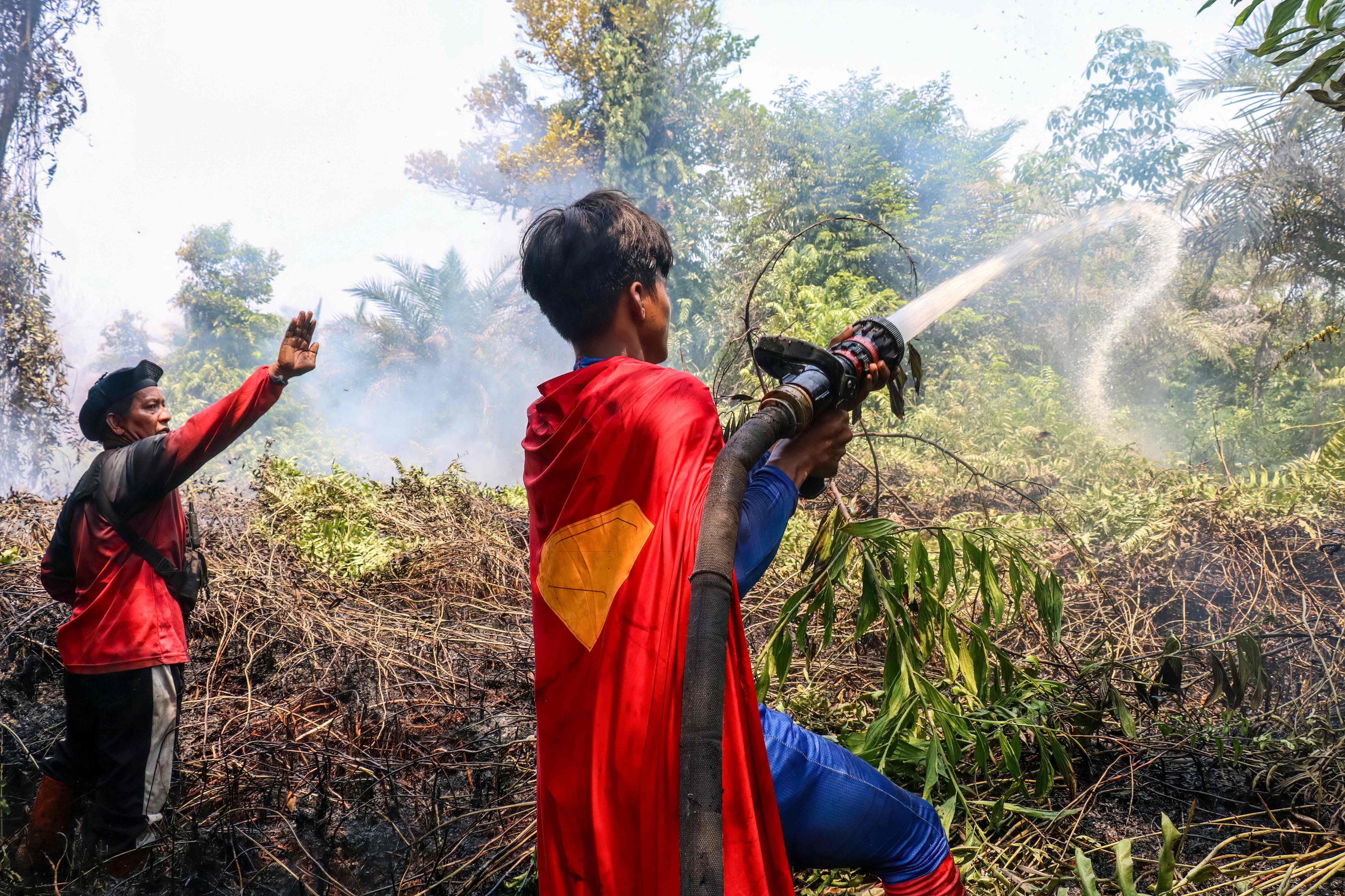 Indonesian student Rudiansyah  dressed in a Superman costume helps extinguish a forest and land fire at Petuk Katimpun in Palangka Raya, Central Kalimantan, last week. Photo: AFP