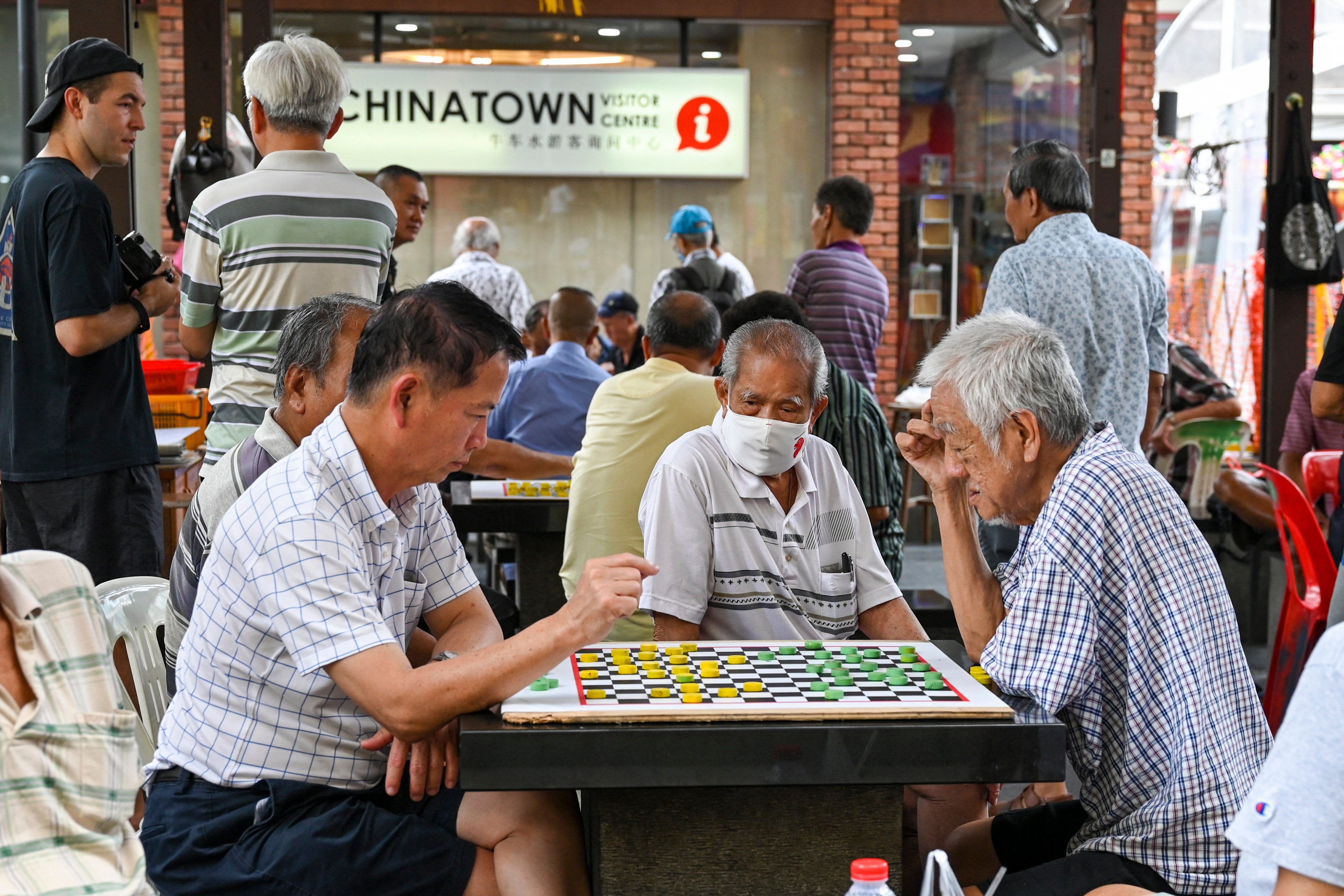 Elderly people play a game of checkers in Singapore's Chinatown. Photo: AFP