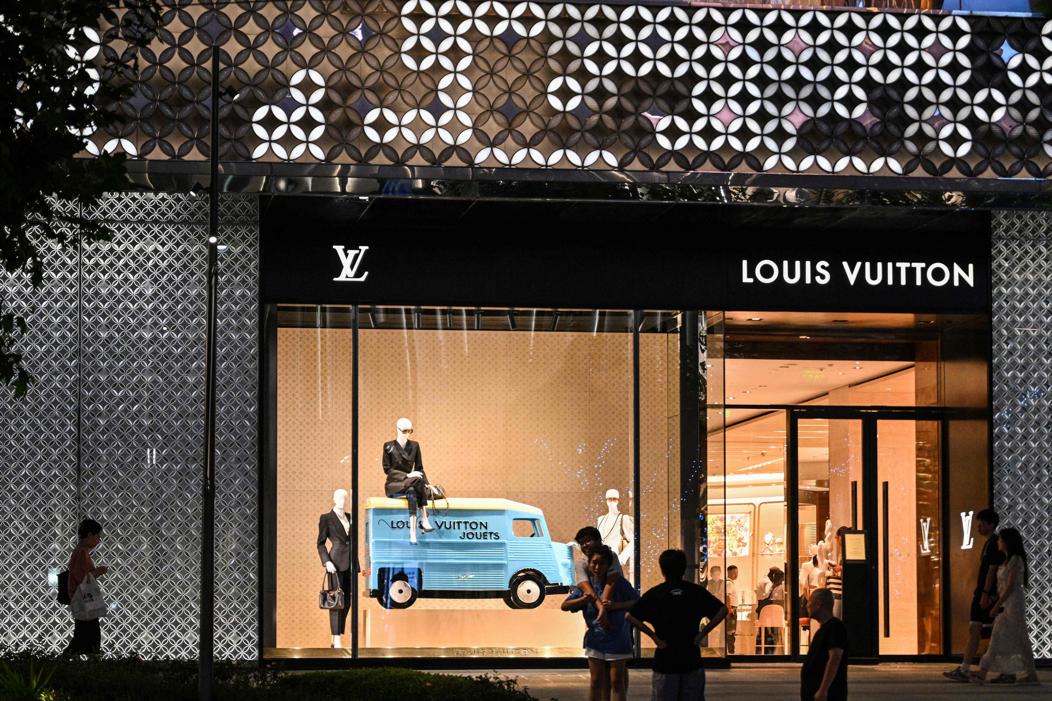 People walk next to a Louis Vuitton shop in Shanghai. Photo: AFP