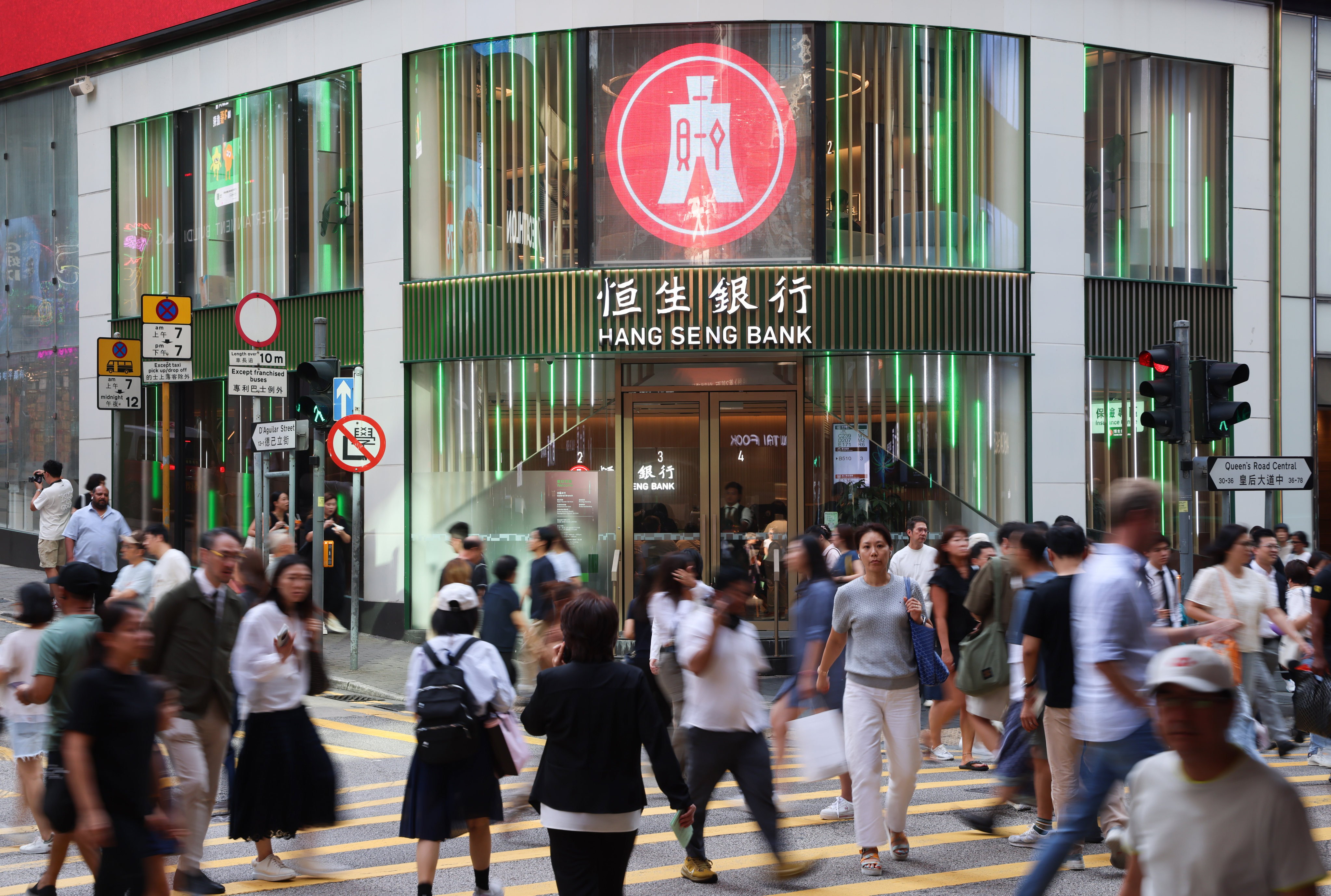 Pedestrians walk past a Hang Seng Bank branch in the Central district of Hong Kong. Photo: Jelly Tse
