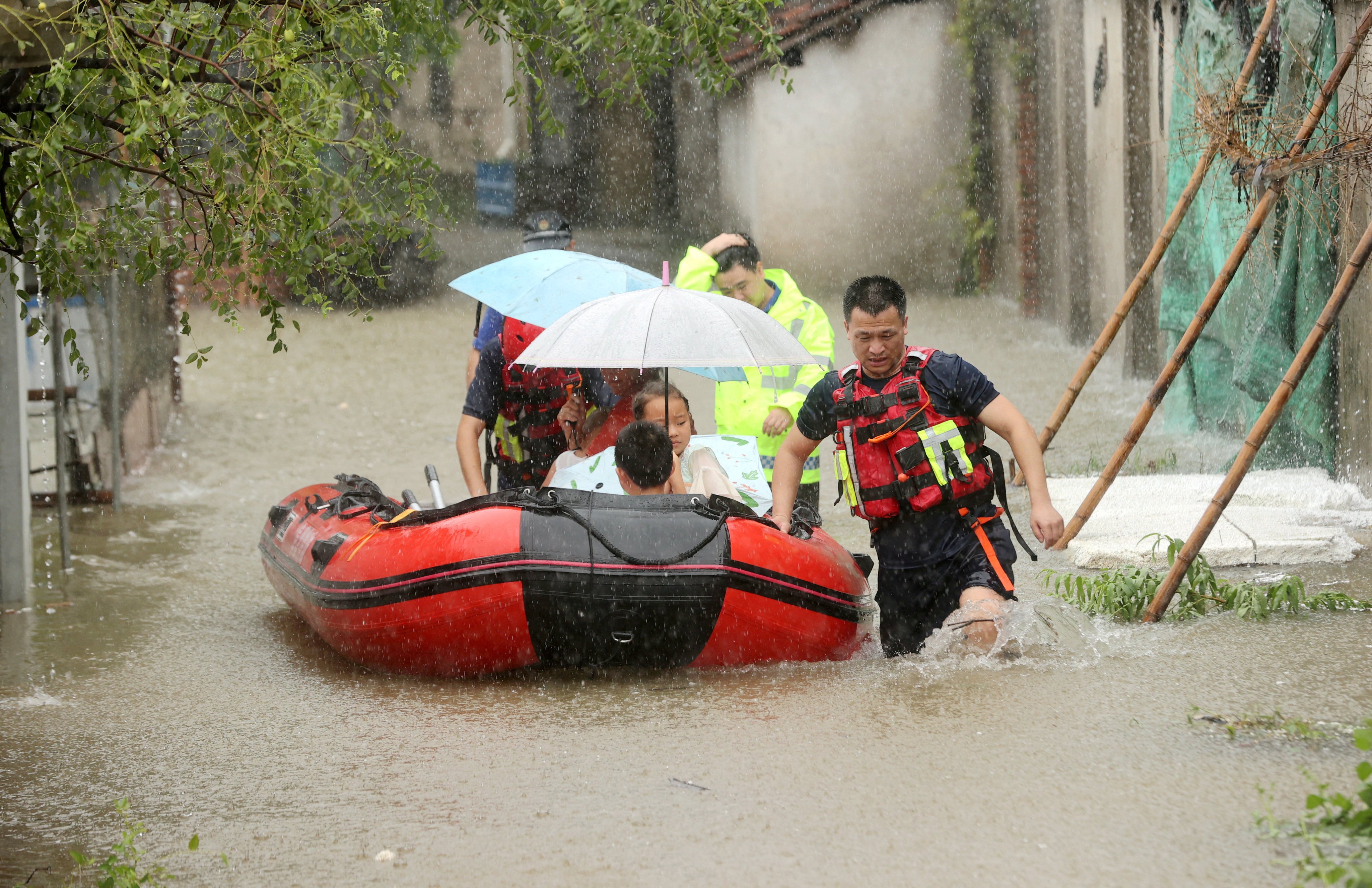 Rescue workers evacuate stranded villagers by lifeboat at a flooded village, following heavy rainfall brought by the remnants of Typhoon Dolphin, in Deqing county, Huzhou, Zhejiang province, China August 14, 2026. China Daily via REUTERS ATTENTION EDITORS - THIS IMAGE WAS PROVIDED BY A THIRD PARTY. CHINA OUT. NO COMMERCIAL OR EDITORIAL SALES IN CHINA.