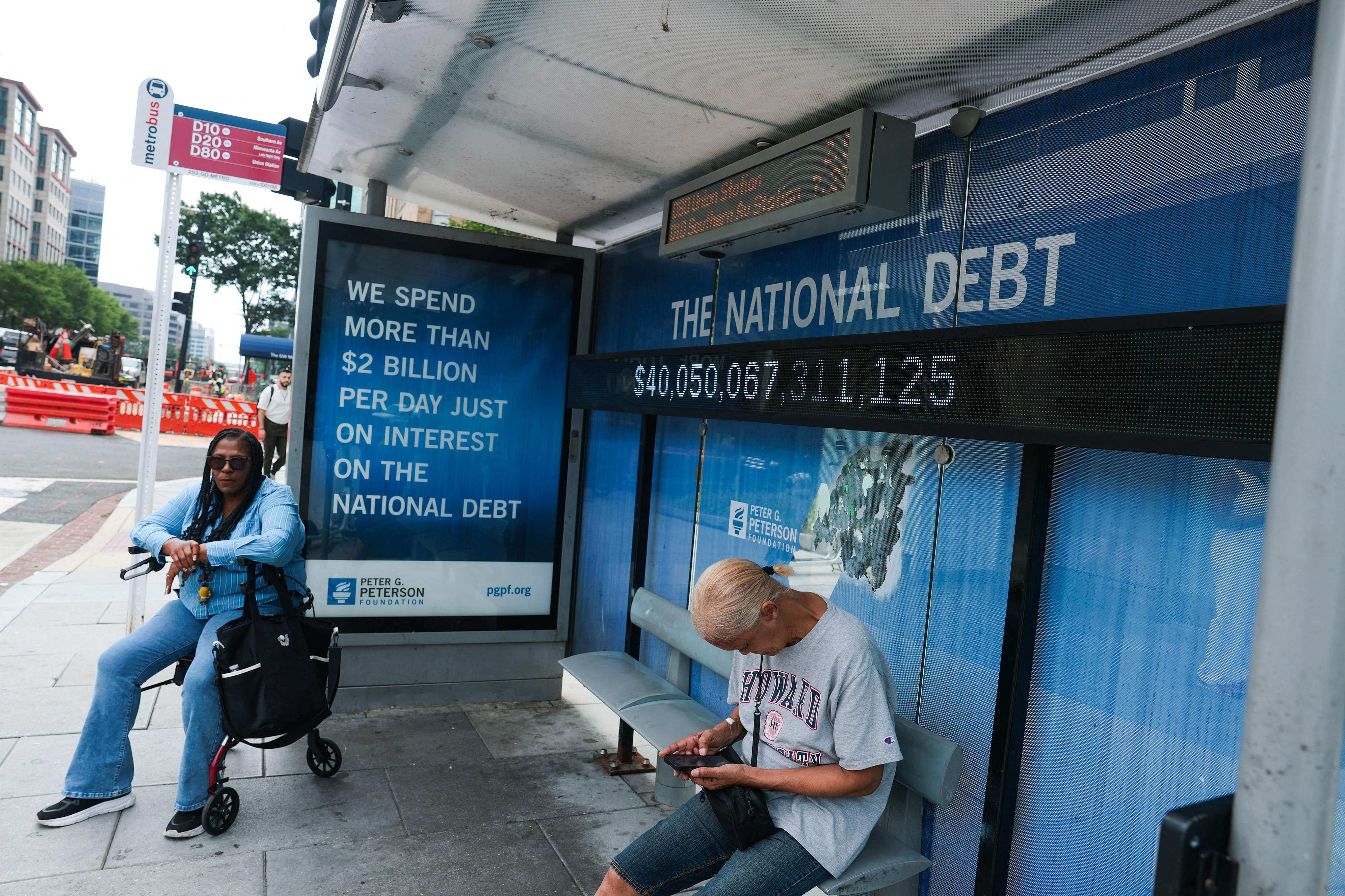 A sign displays the US national debt at a bus stop in Washington on Thursday. Similar signs have been put up across the country, made by a nonpartisan foundation. Photo: Getty Images via AFP