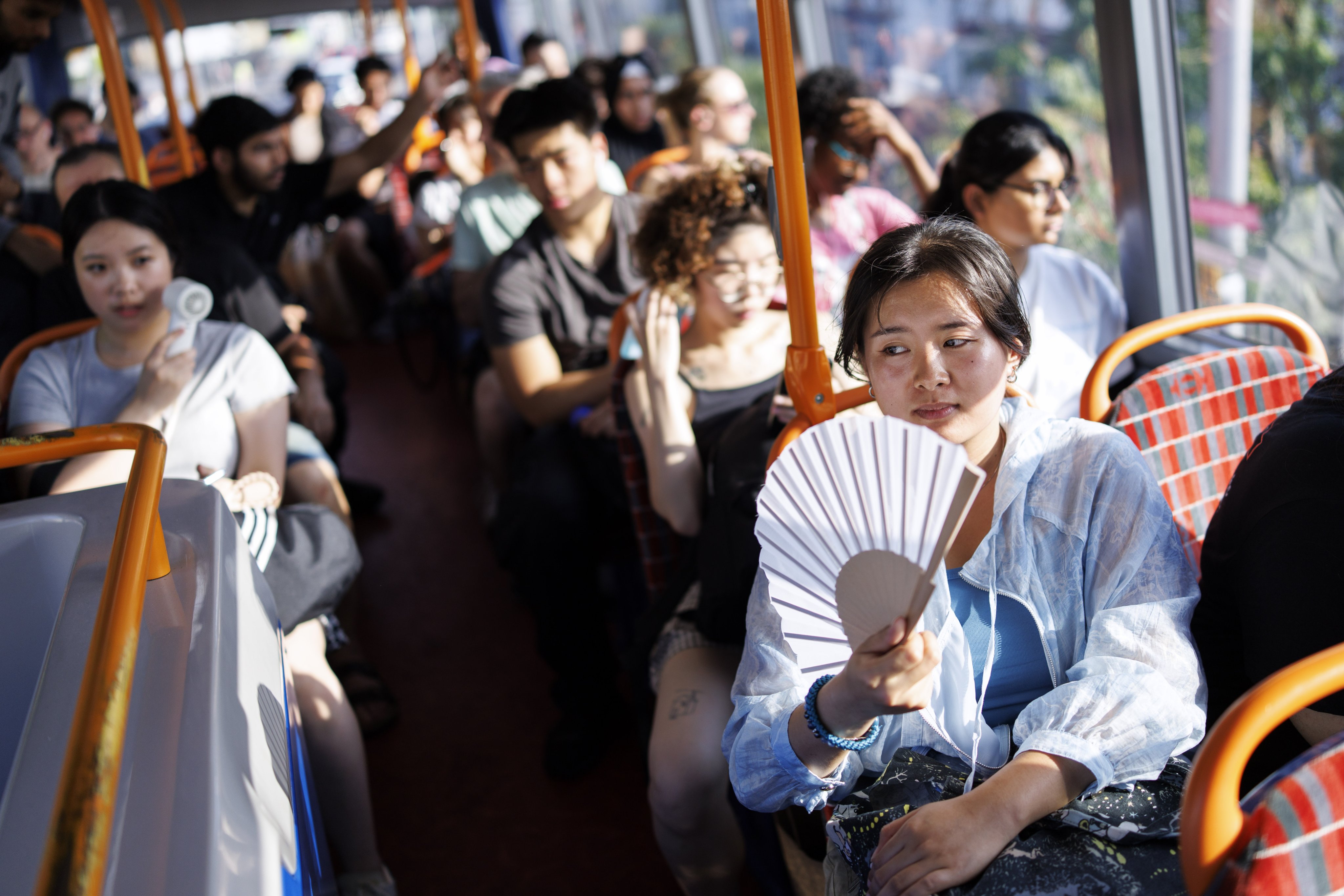 Passengers uses fans to cool down on a bus in London earlier this year as the UK experienced its hottest June day on record. Photo: EPA