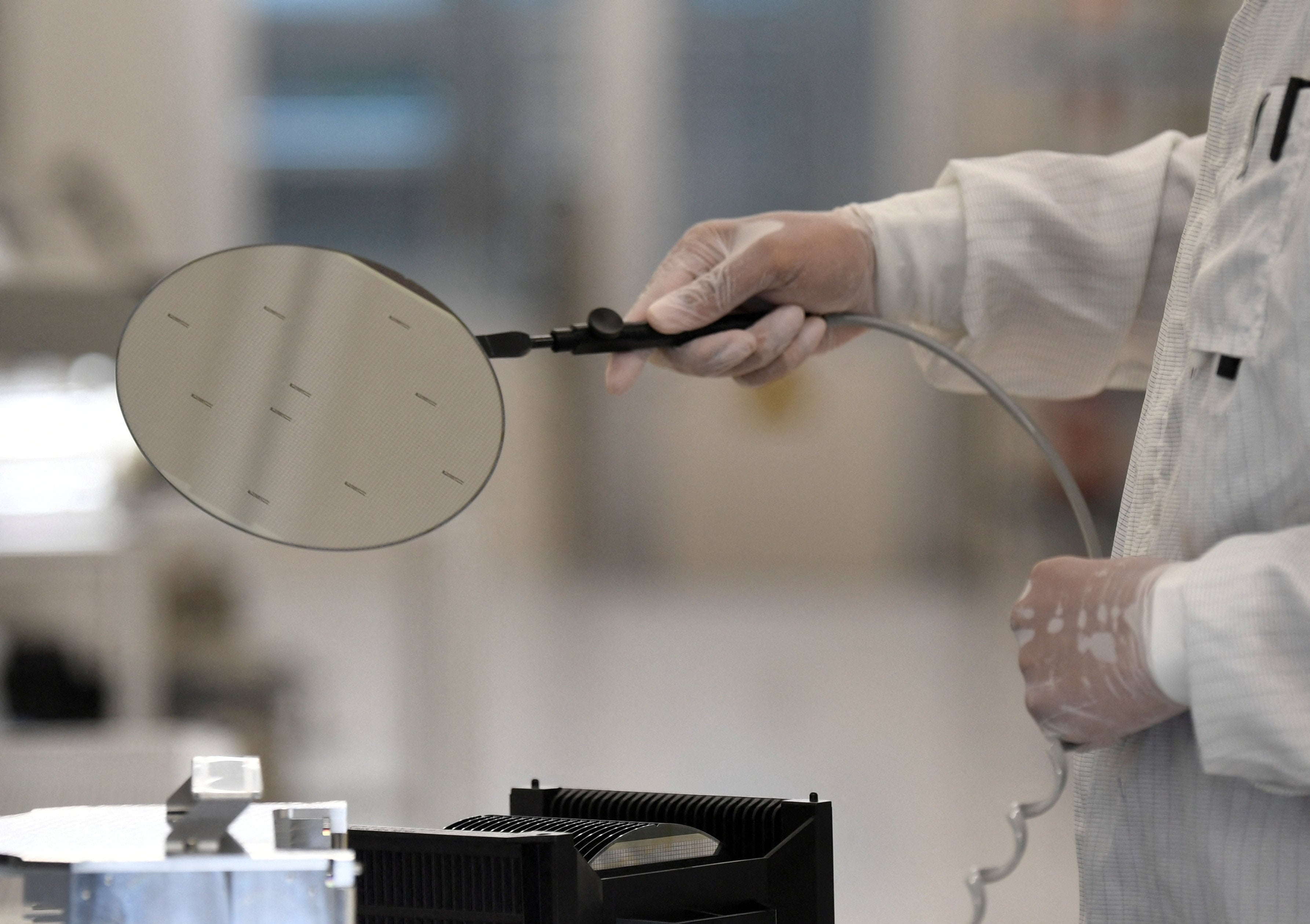An employee works with a wafer on a production line of semiconductor firm Nexperia in Hamburg, Germany, on June 27, 2024. Photo: Reuters