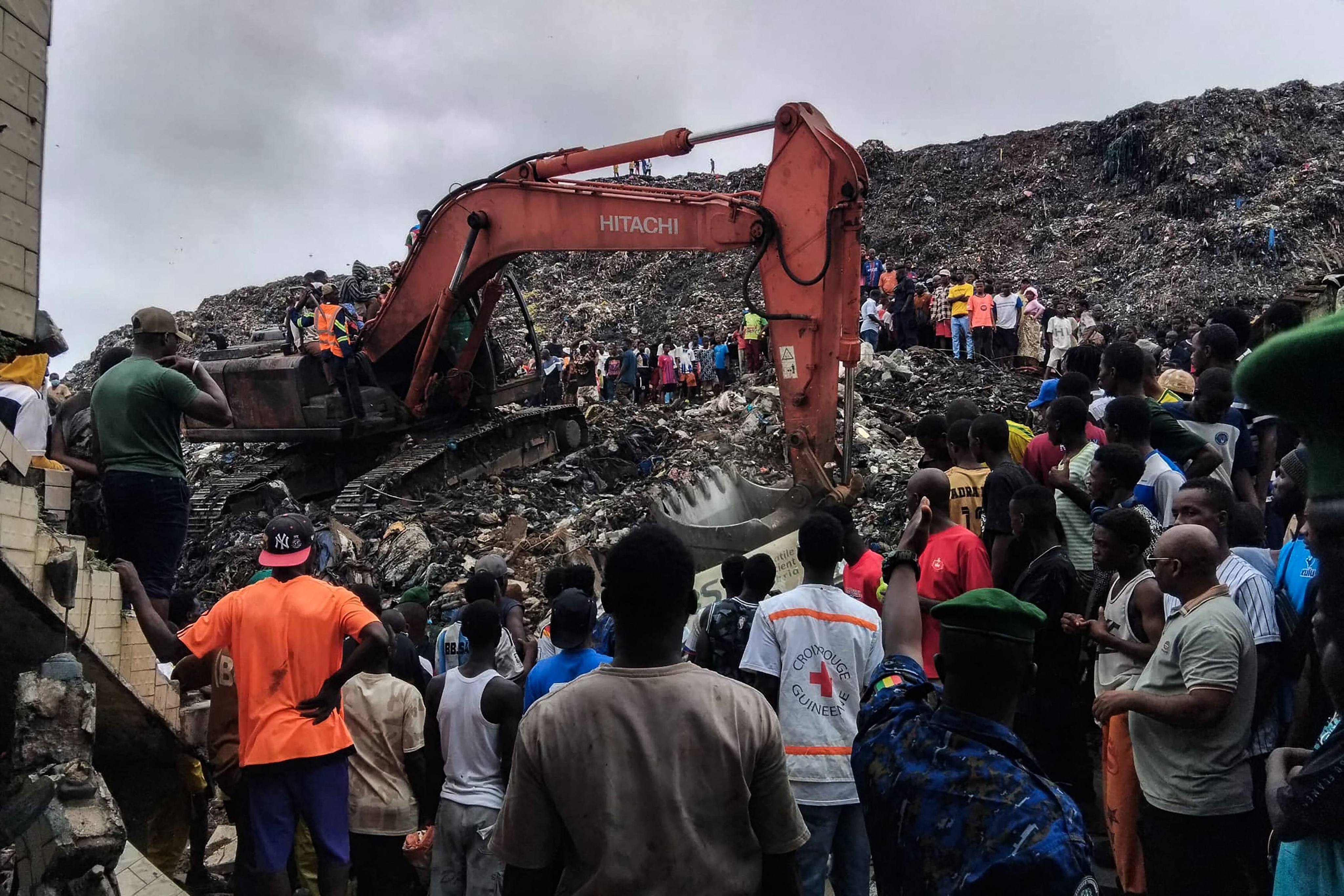 Residents and rescuers use an excavator to search for bodies after a landslide struck the Dar es Salaam dumpsite overnight in Conakry, Guinea on Sunday. Photo: AFP
