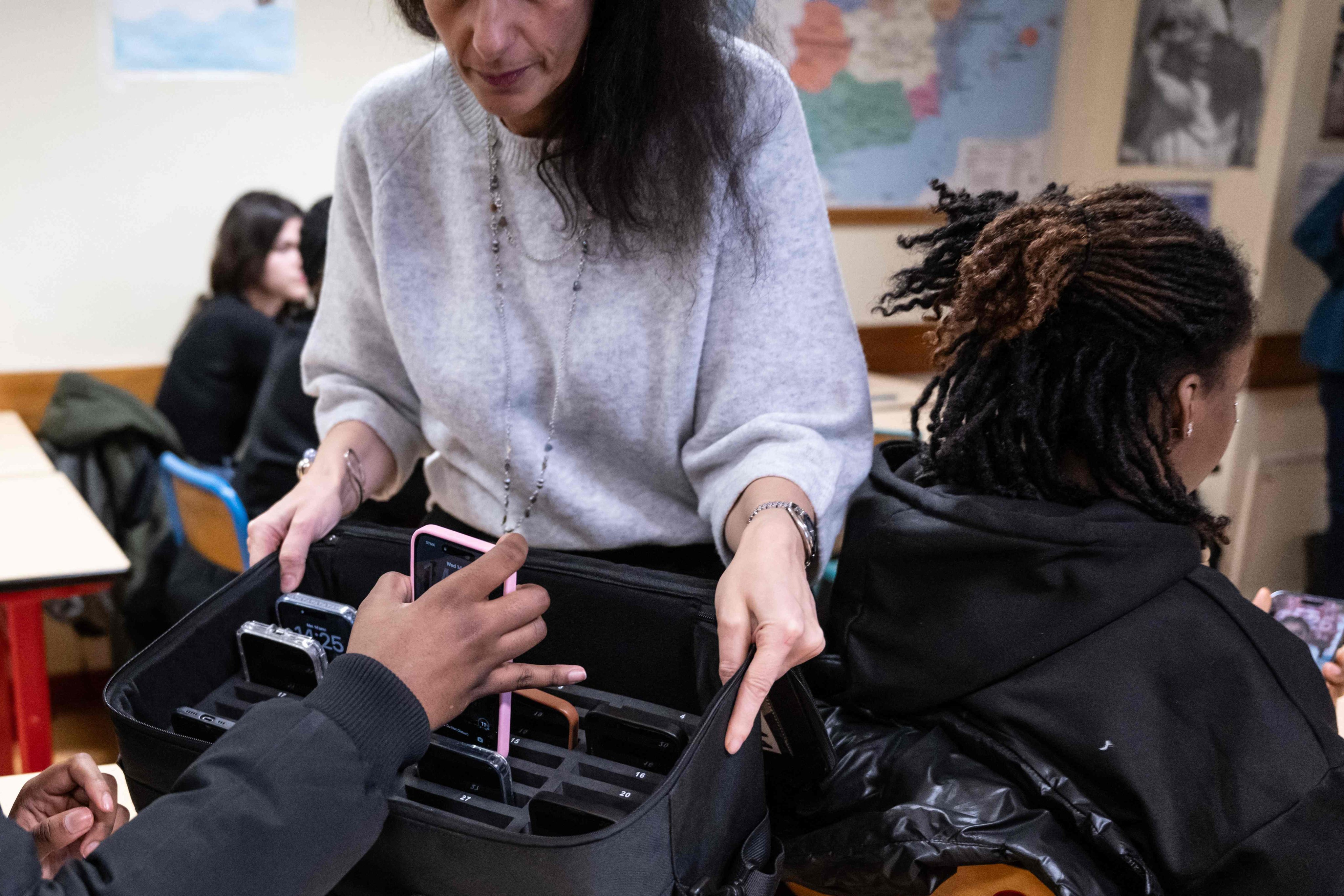 A teacher collects a student’s mobile phone, set aside during classes at the Jean Mermoz vocational high school in Montsoult, in the northern suburbs of Paris, France, in January. Photo: AFP