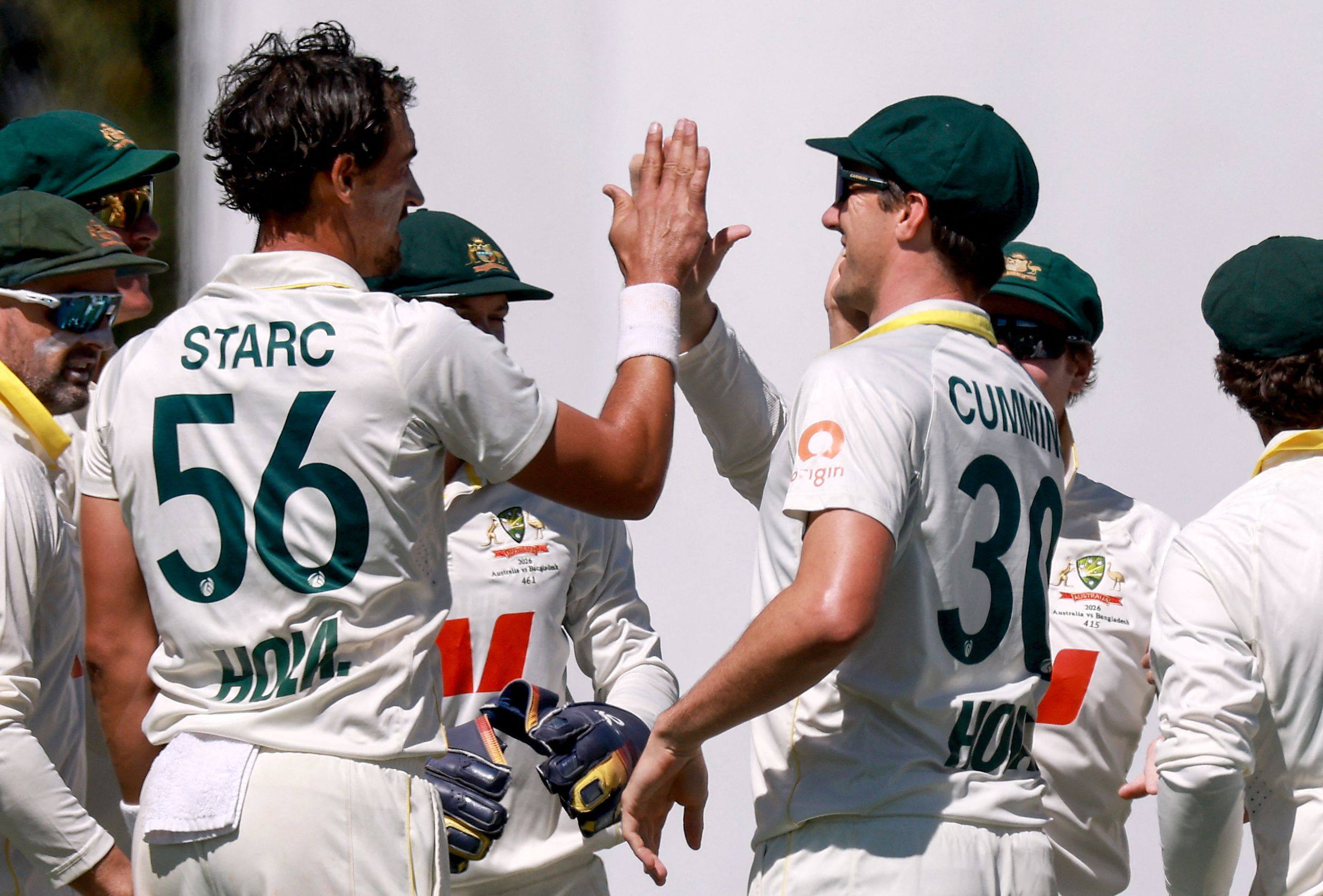 Australias Mitchell Starc (left) celebrates with captain Pat Cummins (right) after dismissing Bangladeshs Shadman Islam during the second Test in Mackay on Sunday. Photo: AFP