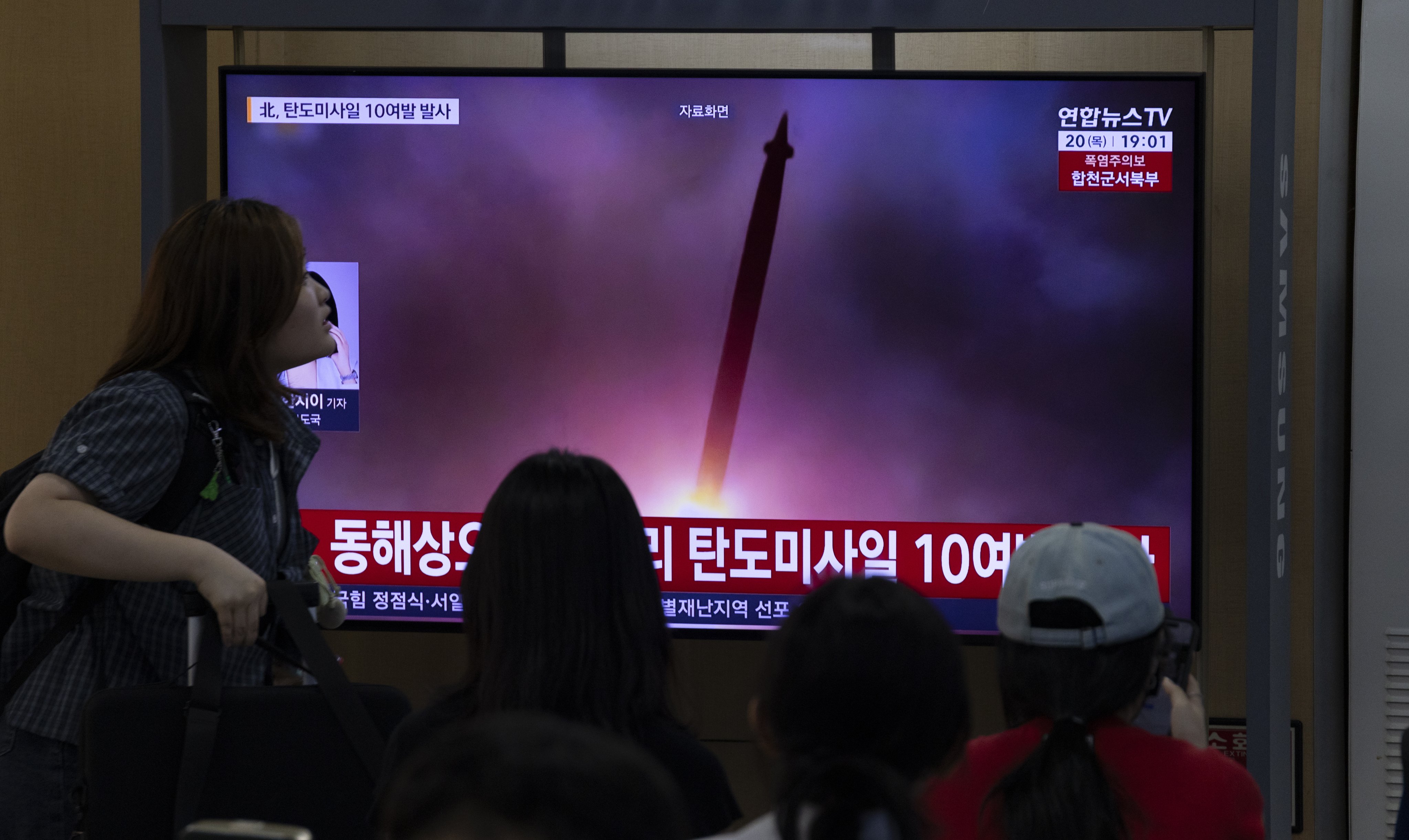 Passengers at a station in Seoul watch a news report about North Korea’s latest missile launches. Photo: EPA