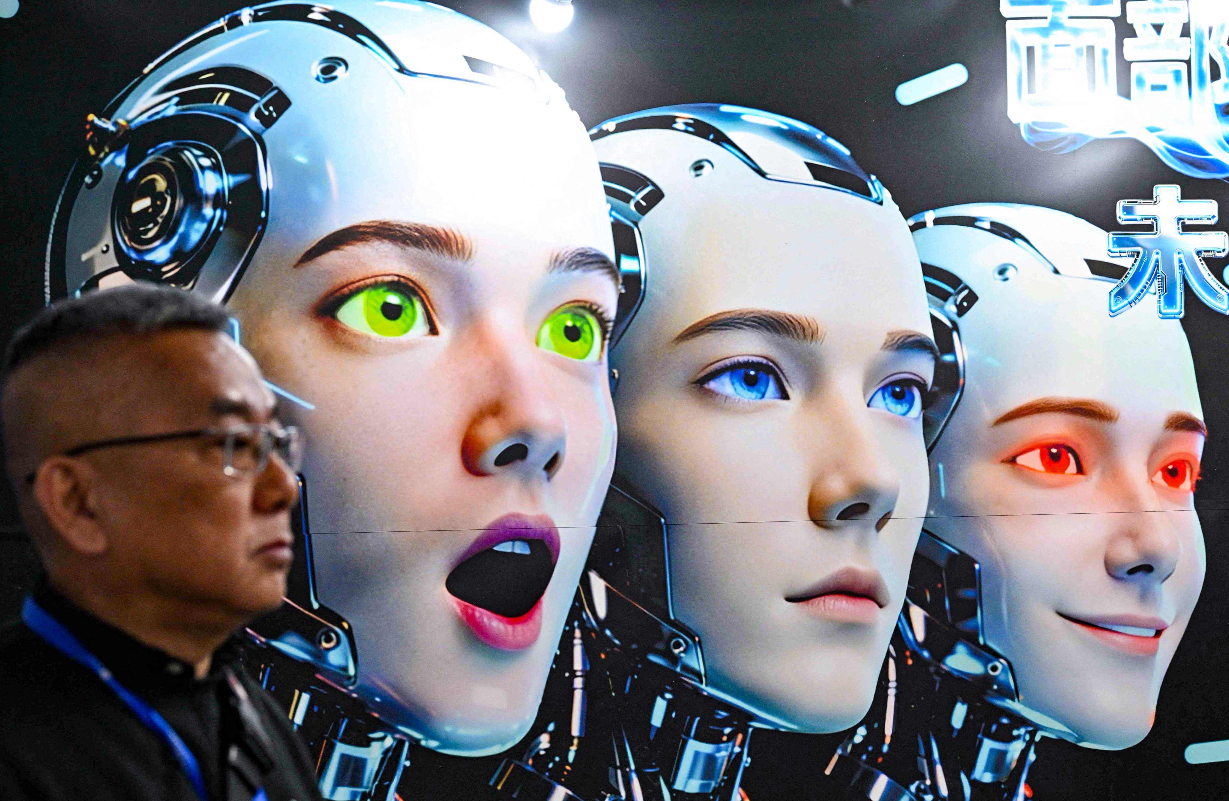 A man stands next to a poster showing robots mimicking human expressions from Shenzhen Xiaoquan Technology during the International AI Application and Robotics Innovation Exhibition in Beijing on March 18. Photo: AFP