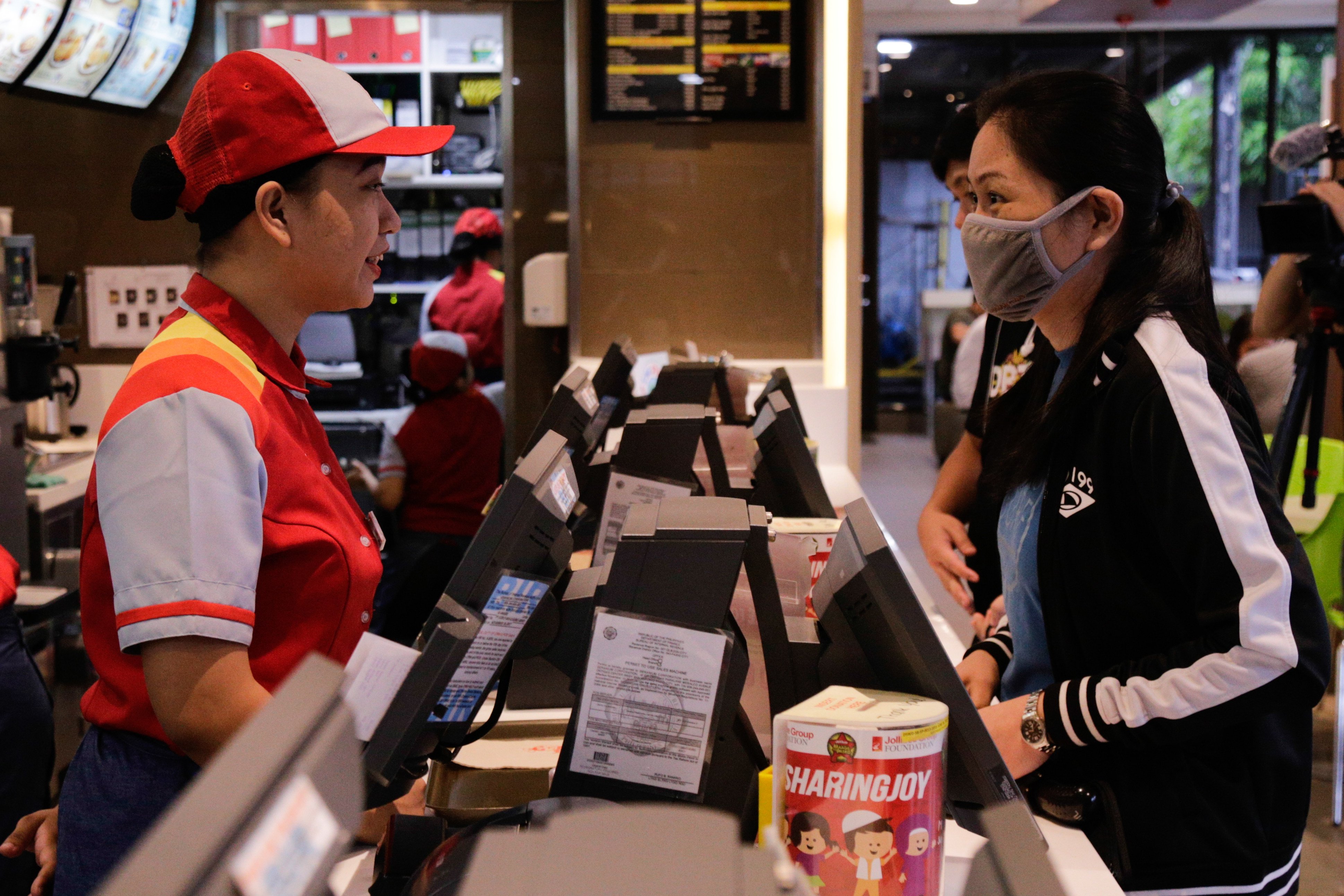 A Jollibee staff member takes orders from a customer at an outlet in Ortigas Center, Pasig City, Philippines, on May 27, 2019. Photo: Jansen Romero