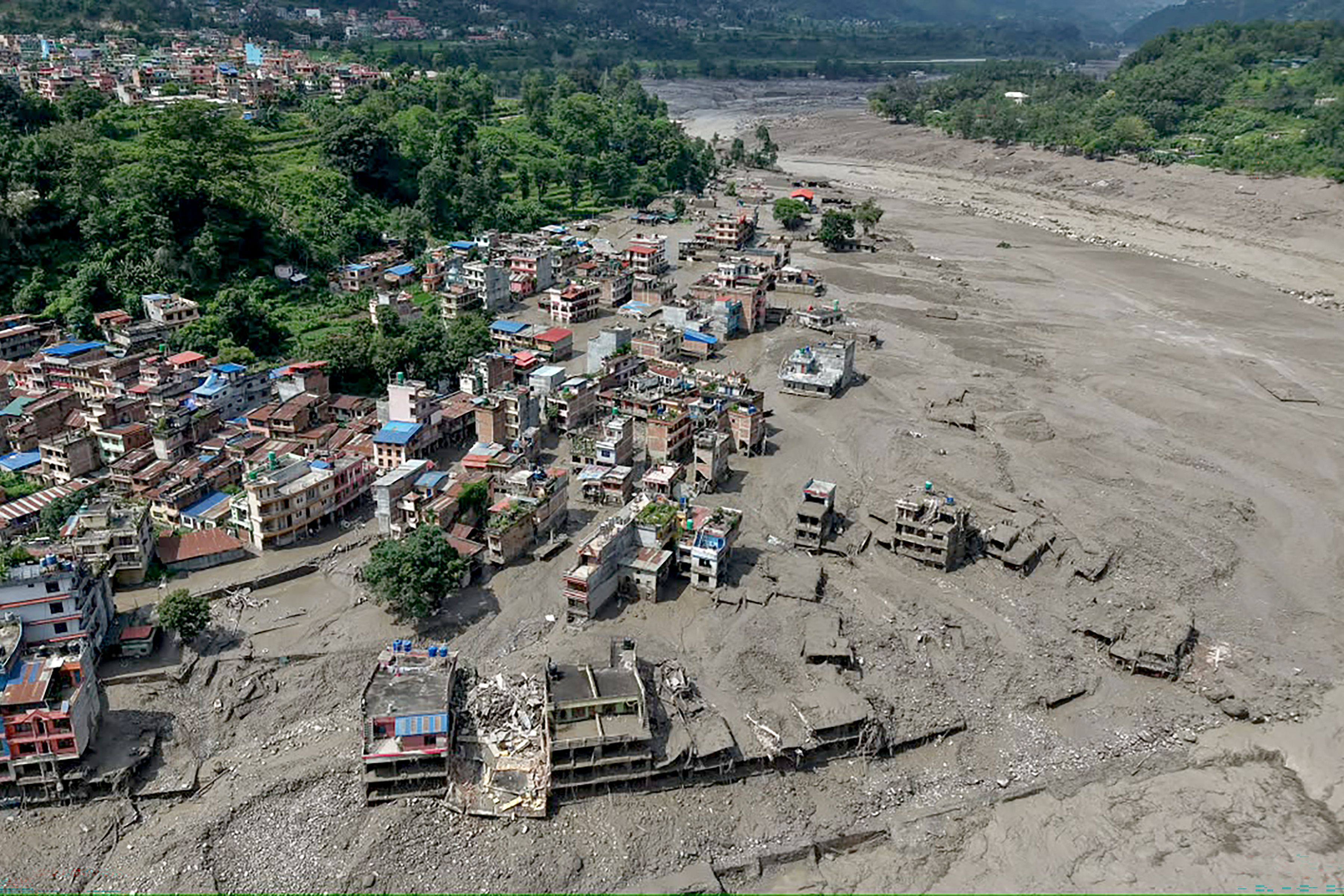 Houses lie partially submerged in muddy water along a riverside after flash floods at Trishuli Bazar in Nepal’s Nuwakot district on Wednesday. Photo: AFP