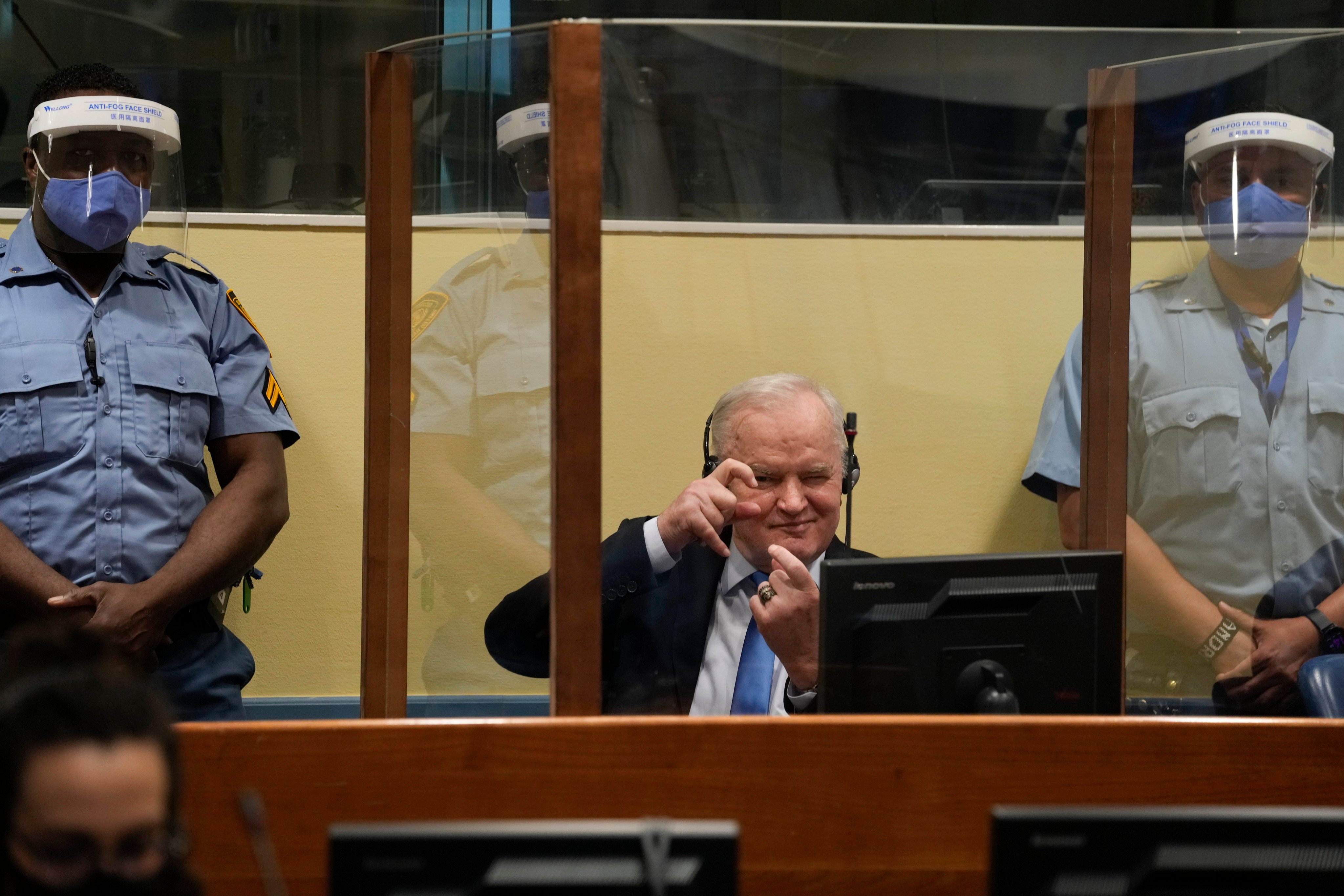 Former Bosnian Serb military chief Ratko Mladic imitates taking pictures as he sits in the courtroom in The Hague, Netherlands, in 2021. Photo: AP