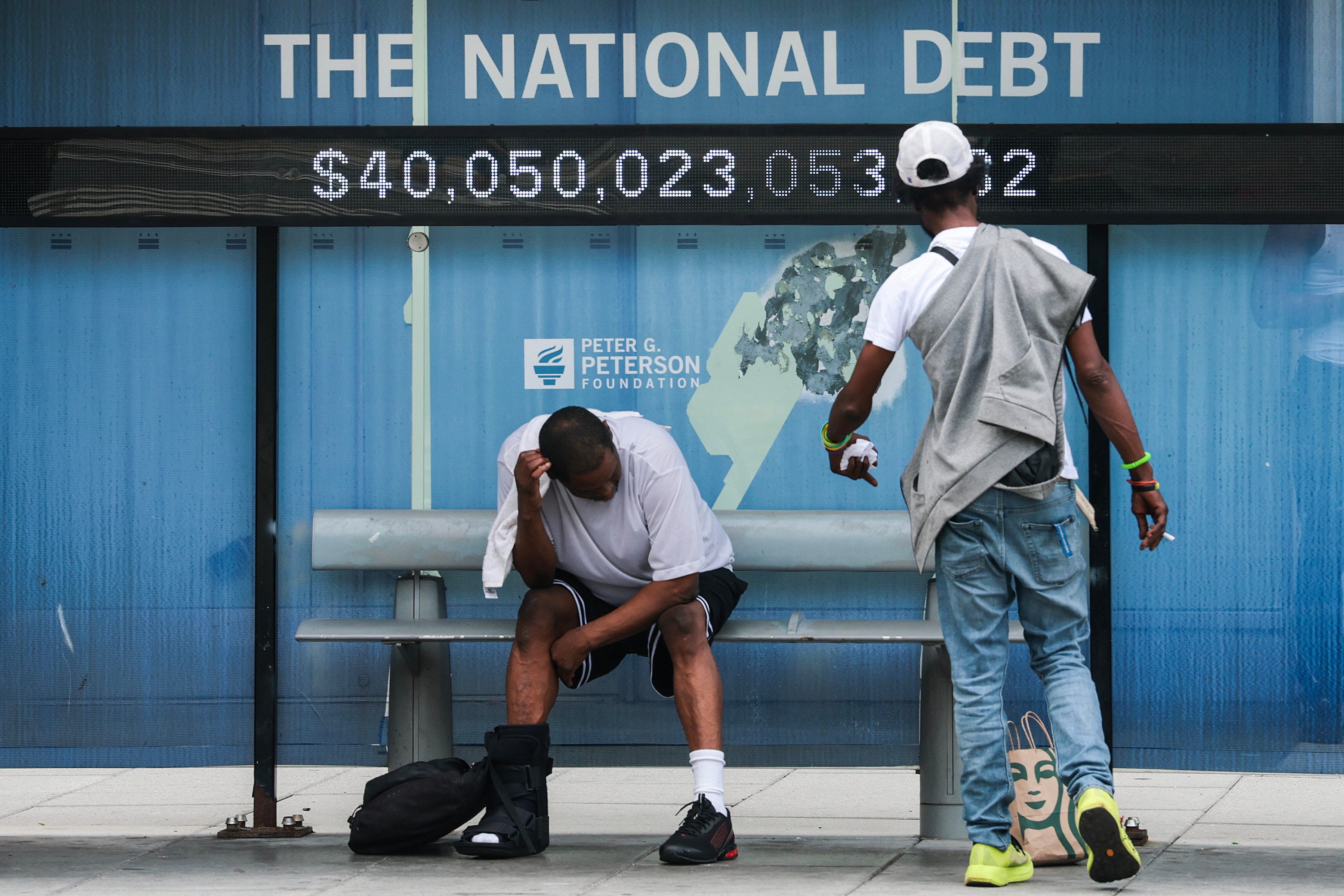 A sign displays national debt at a bus stop in Washington on August 20. Similar signs have been put up across the US by the nonpartisan Peter G. Peterson Foundation. Photo: Getty Images