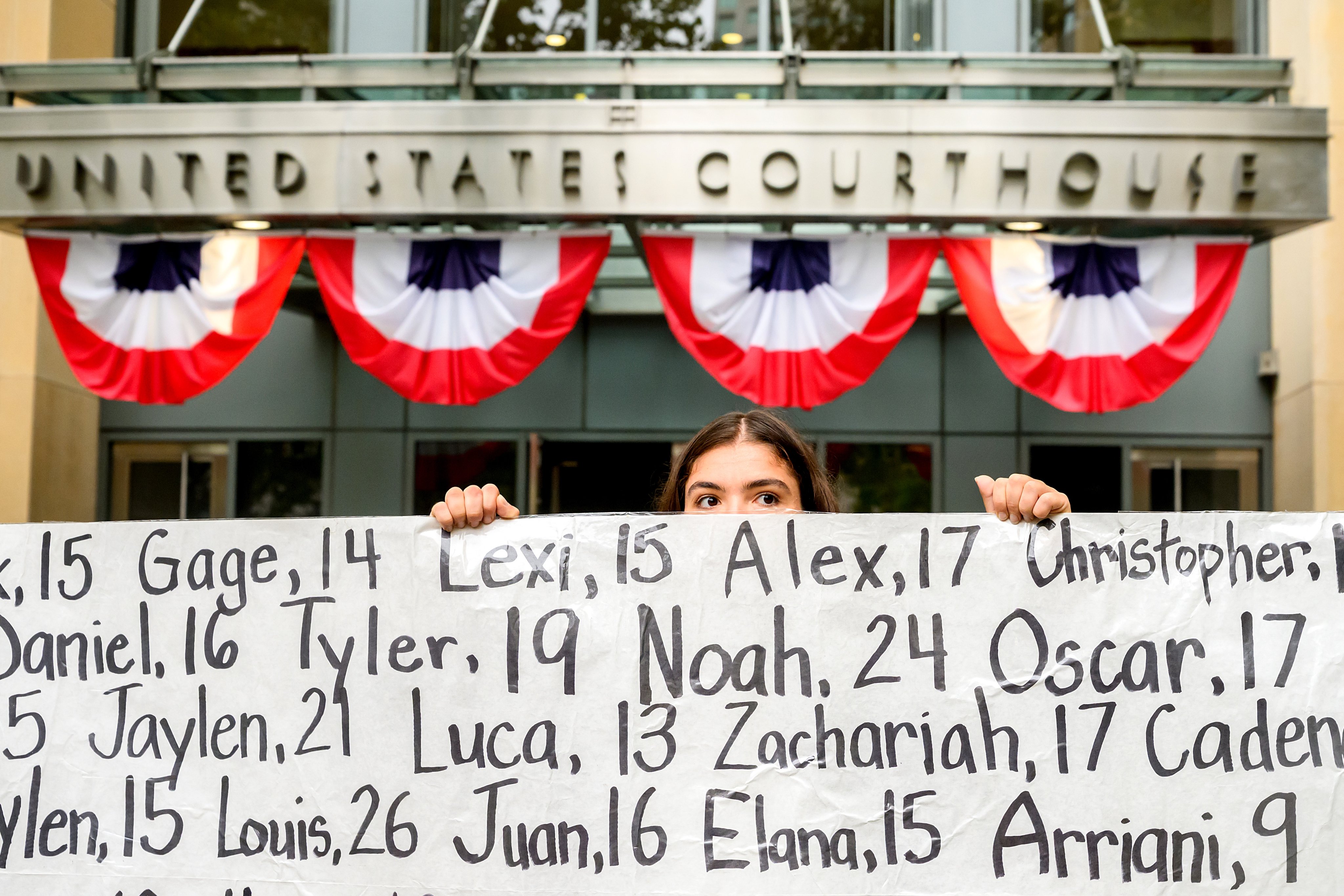 Olivia Konar holds a banner naming young victims of alleged social media harms outside the federal courthouse in Oakland, California. Photo: AP