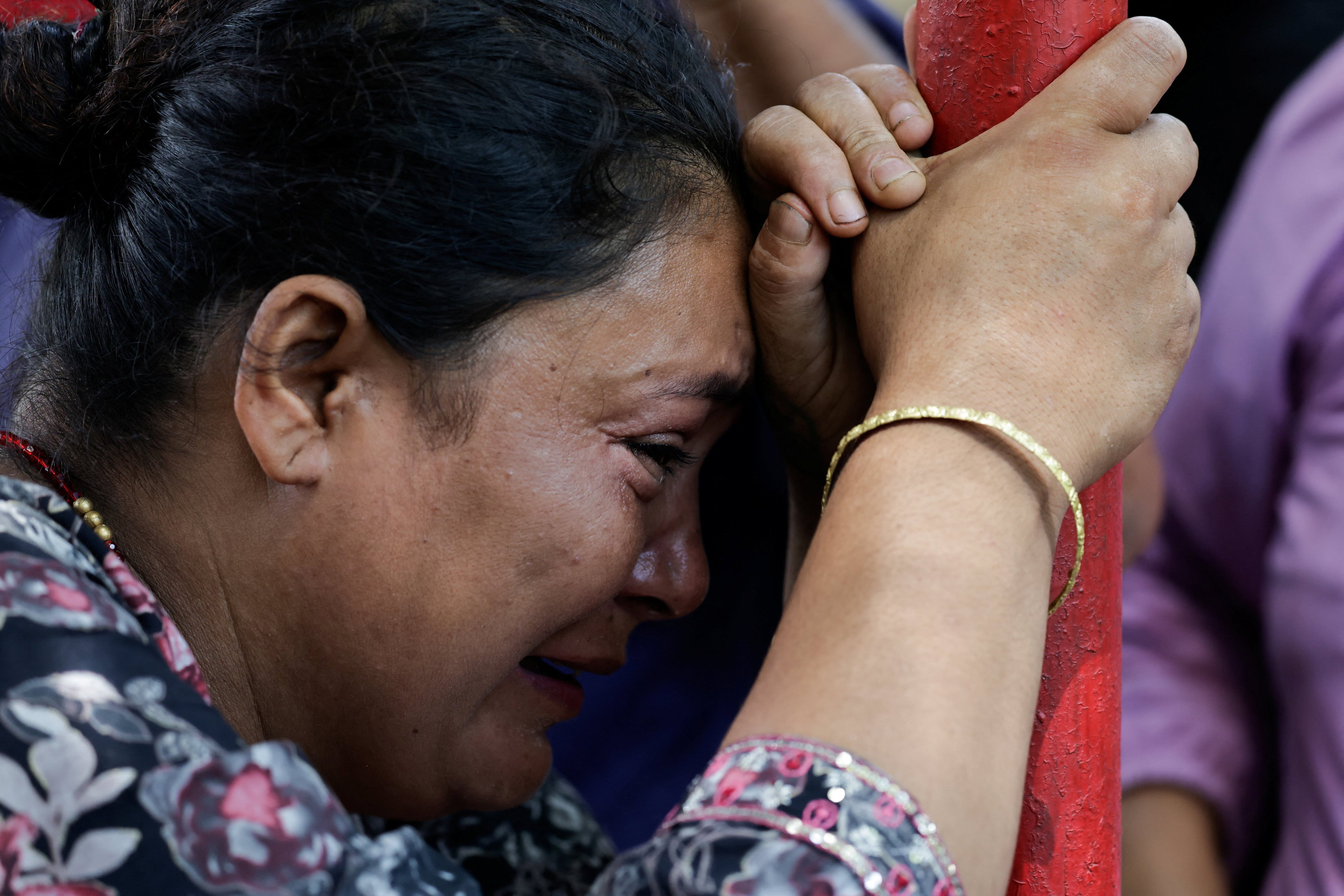 A woman cries as she waits for updates on the whereabouts of her missing family member outside the Maithali Barrack, an army training centre, which serves as a primary base to airlift survivors from Rasuwa at Trishuli in Nuwakot district, Nepal, August 27, 2026. REUTERS/Navesh Chitrakar
