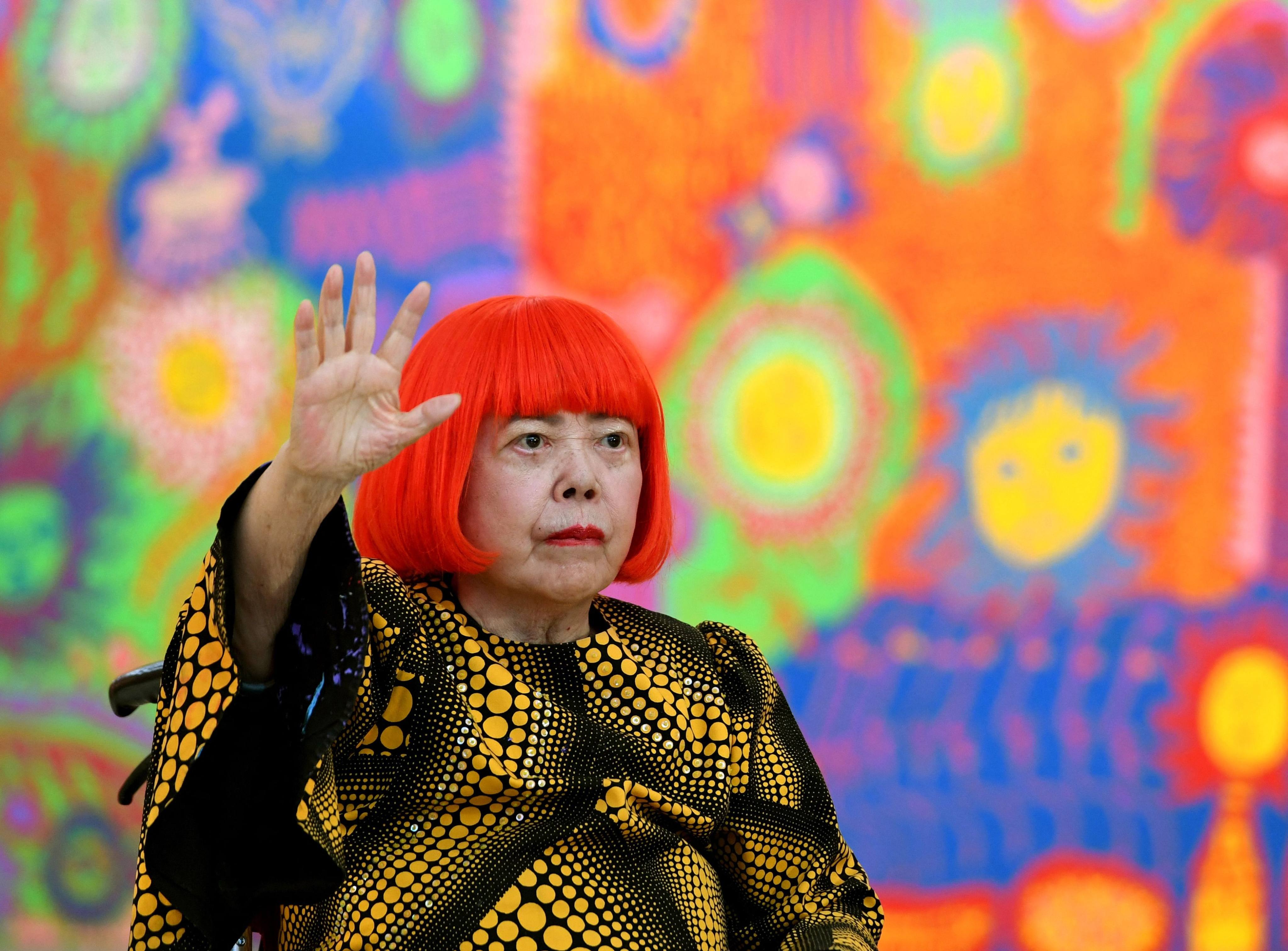 Japanese artist Yayoi Kusama waves during a press preview of her exhibition titled “My Eternal Soul” at the National Art Centre in Tokyo on February 21, 2017. Photo: AFP